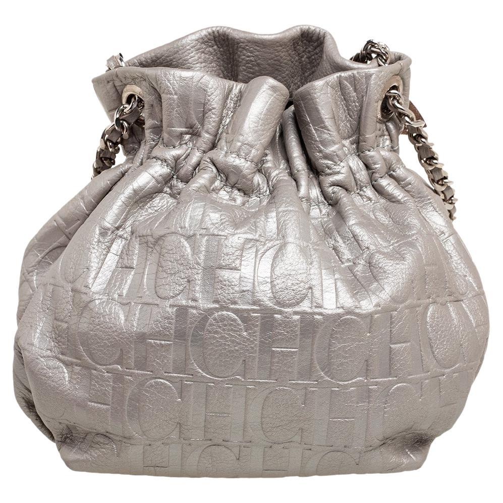 Crafted from monogram-embossed leather, this Carolina Herrera bag will be a great party addition. Elevated with a bow design on the front, it features a chain-leather strap and a fabric interior. The metallic-colored bag will safely house your