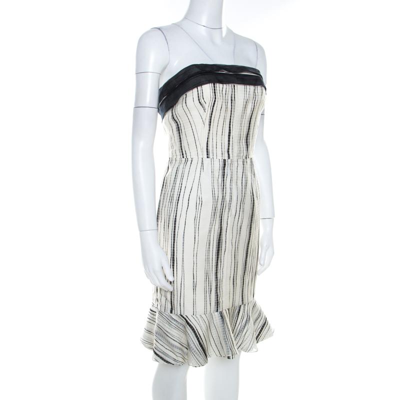 How lovely is this dress from Carolina Herrera! The monochrome creation is made of 100% silk and features a flouncy design at the rear. It flaunts a strapless silhouette and an irregular striped pattern all over. Pair it with stilettoes and a clutch