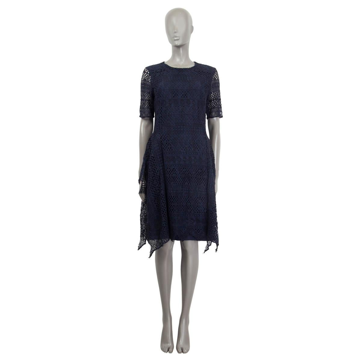 100% authentic Carolina Herrera broderie anglaise dress in navy blue cotton (45%), viscose (28%) and polyamide (27%). Features an asymmetric hemline and short semi sheer sleeves. Opens with a concealed zipper and a hook at the back. Lined in navy