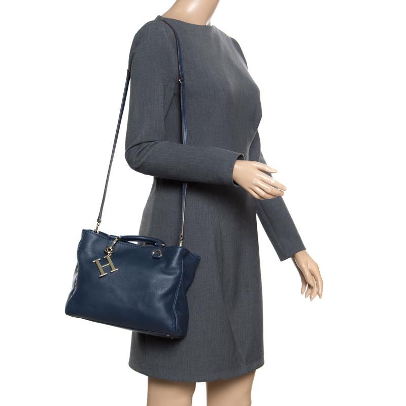 This stunning navy blue handle bag is from the house of Carolina Herrera. Crafted from leather, and lined with fabric on the insides, the bag features dual rolled top handles, a gold-tone logo charm, protective metal feet, and a detachable shoulder