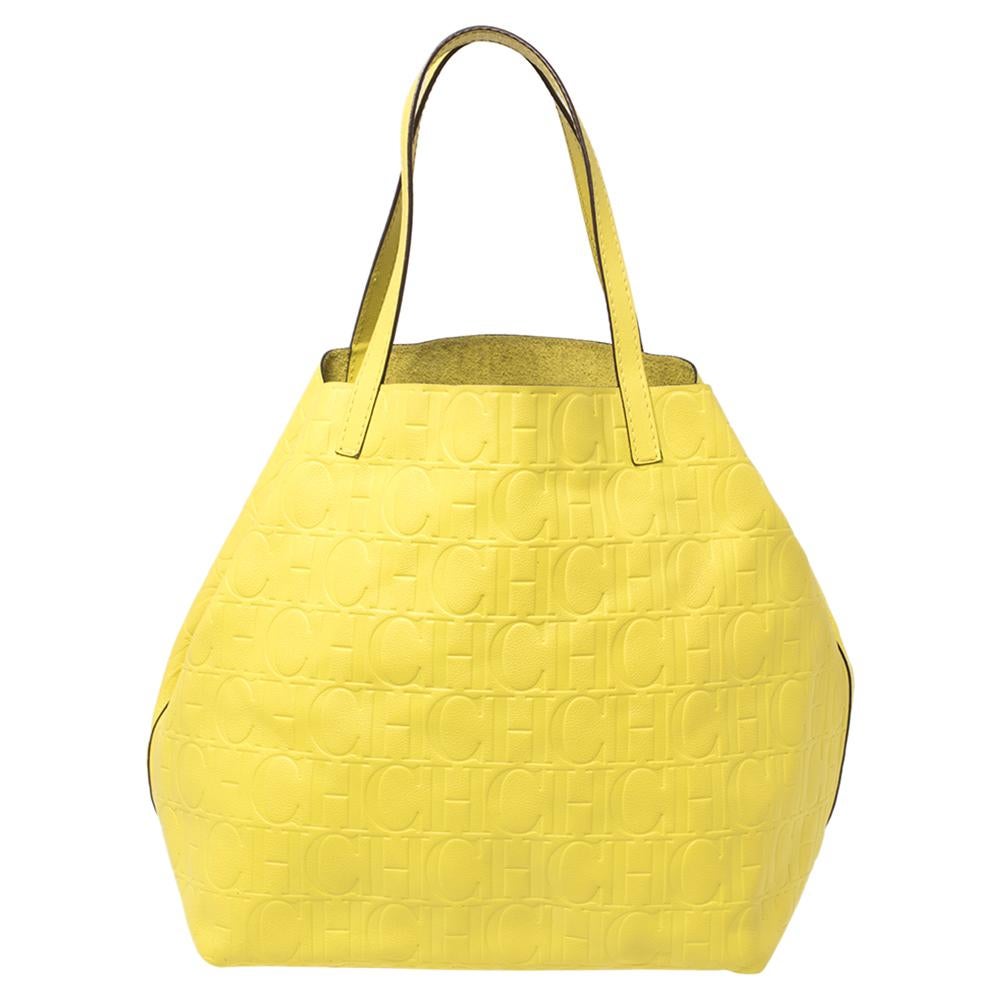This stunning tote by Carolina Herrera is a must-have. Crafted from the brand's signature monogram leather, it comes in a lovely neon yellow shade. It is equipped with a spacious interior and two handles. It is functional, durable and has a classic