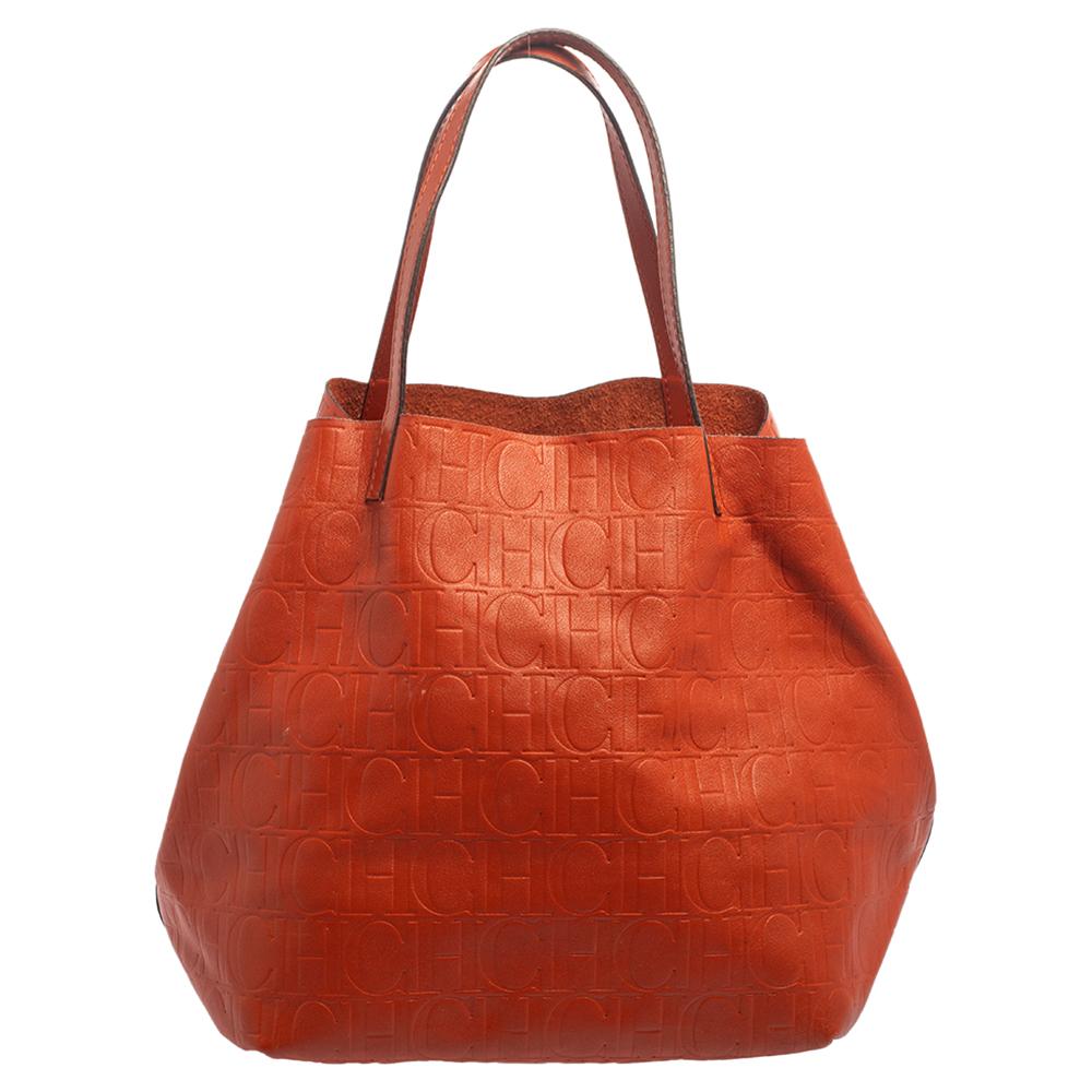 This stunning tote by Carolina Herrera is a must-have. Crafted from the brand's signature monogram leather, it comes in a lovely orange shade. It is equipped with a spacious interior and two handles. It is functional, durable and has a classic