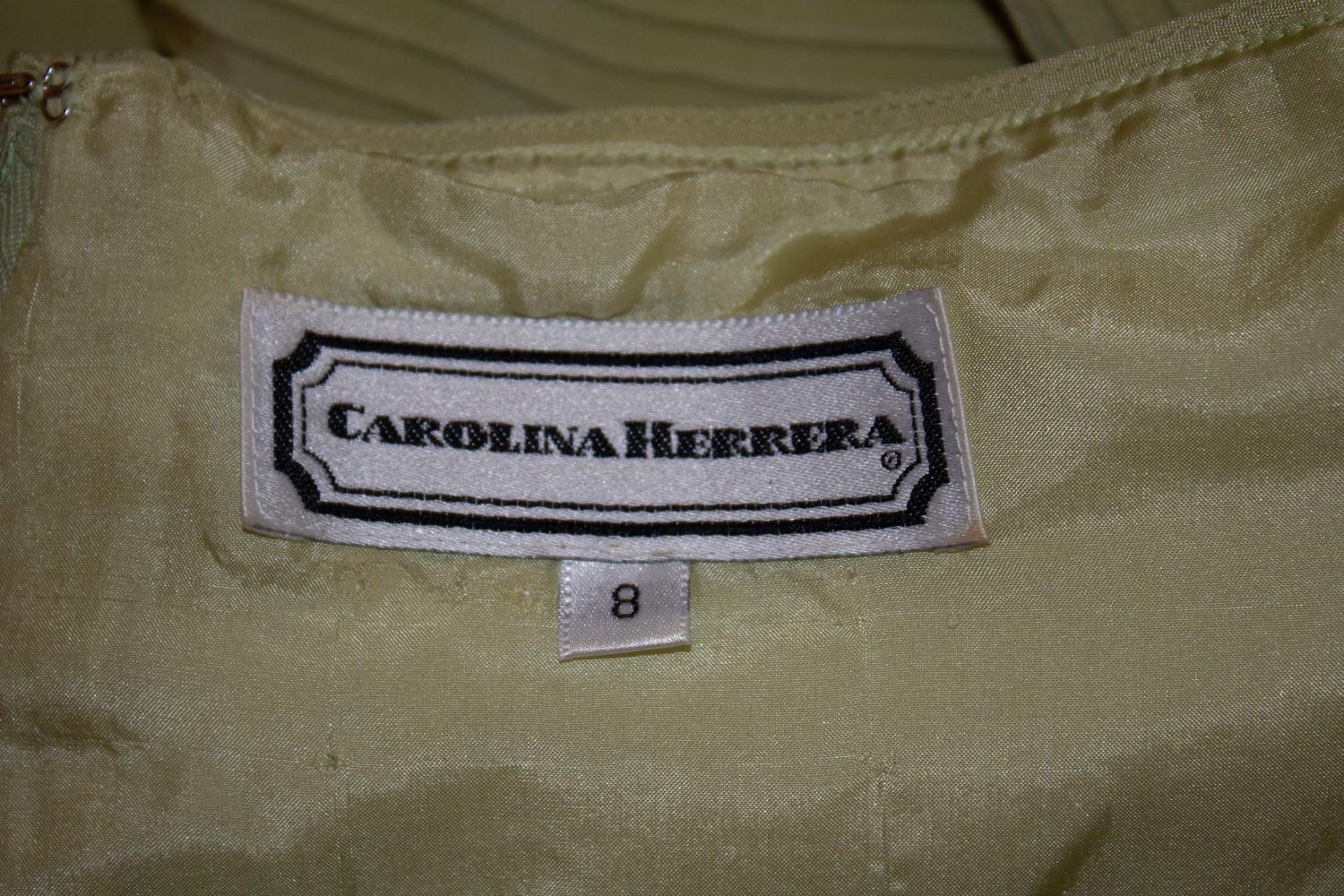 Un grazioso abito vintage di Carolina Herrera, perfetto per un cocktail o una cena.  In seta verde pistacchio, l'abito presenta un'imbottitura laterale e un dettaglio di pieghe sul corpetto. Ha maniche a mantellina, cerchi per il reggiseno, una zip