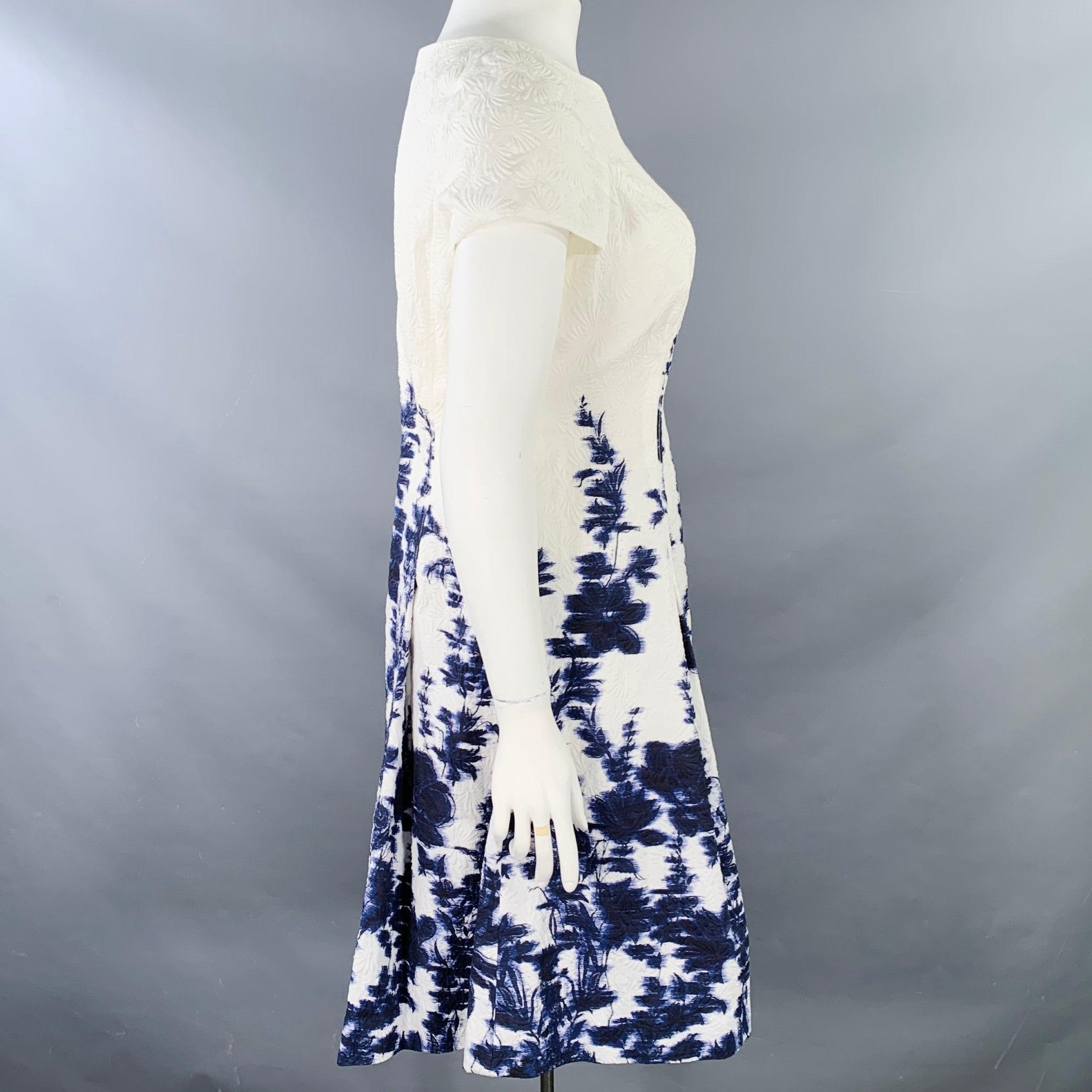 CAROLINA HERRERA dress
in a white and indigo cotton blend featuring an abstract floral pattern with indigo color dyed floral print, pleated skirt, and back zipper closure. Made in Italy.Very Good Pre-Owned Condition. Minor mark on left sleeve.