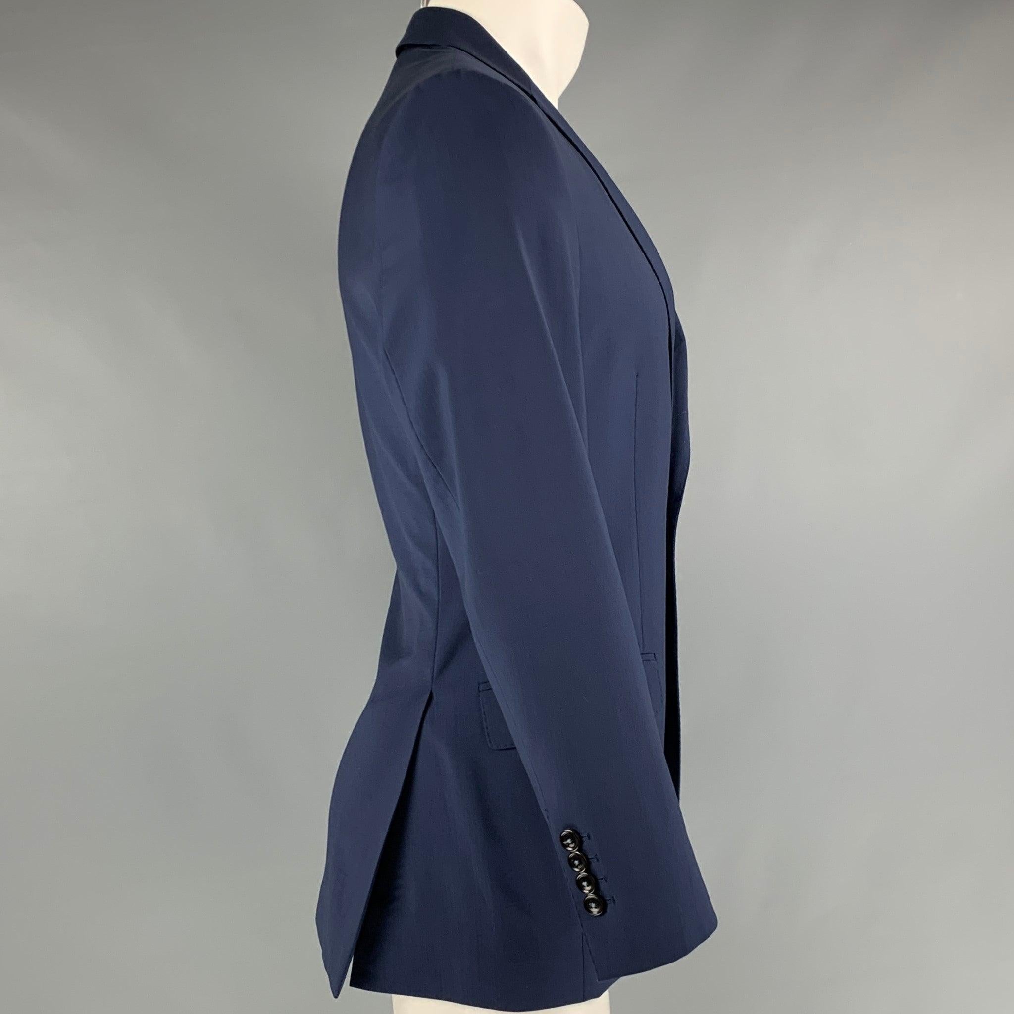 CAROLINA HERRERA
sport coat in a navy virgin wool featuring a notch lapel, flap pockets, double back vent, and a double button closure. Made in Italy. Very Good Pre-Owned Condition. Minor mark on lapel. 

Marked:   38 R 

Measurements: 
 
Shoulder: