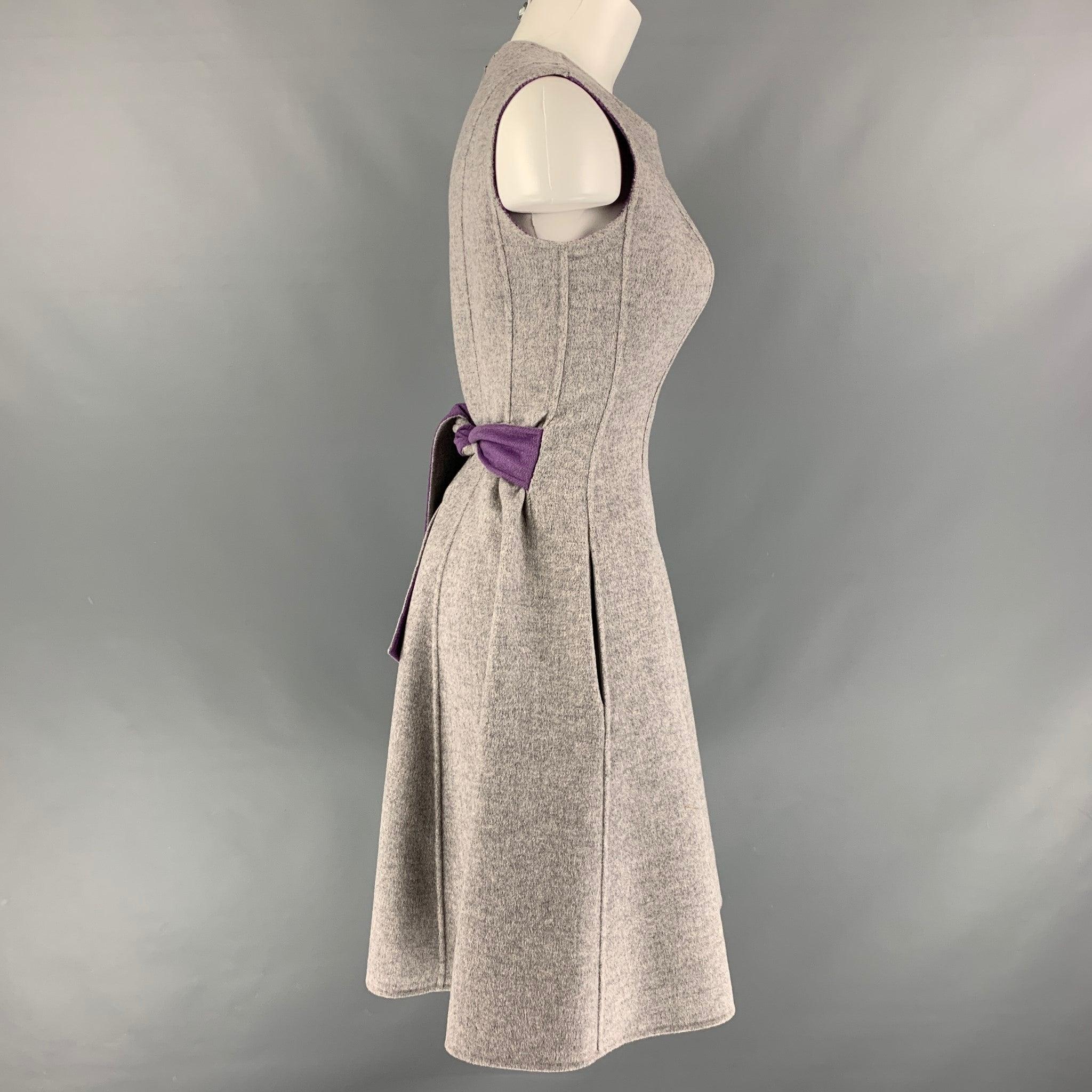 CAROLINA HERRERA dress comes in a grey and purple heather wool fabric featuring two pockets, sleeveless style, a-line silhouette, belt at back and full back zipper closure. Very Good Pre-Owned Condition. 

Marked:   4 

Measurements: 
 
Shoulder: 15