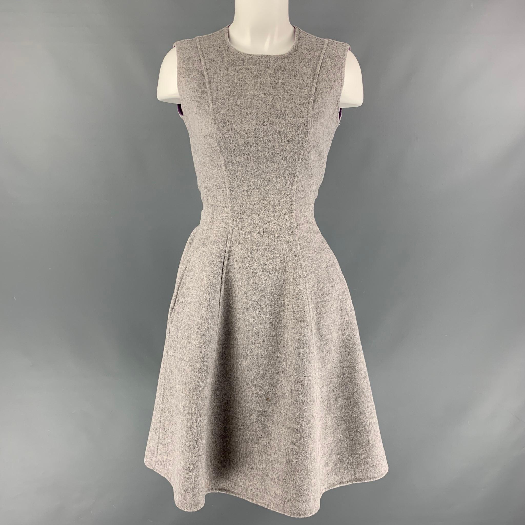 CAROLINA HERRERA dress comes in a grey and purple heather wool fabric featuring two pockets, sleeveless style, a-line silhouette, belt at back and full back zipper closure. Matching coat also available.

Very Good Pre-Owned Condition.
Marked: