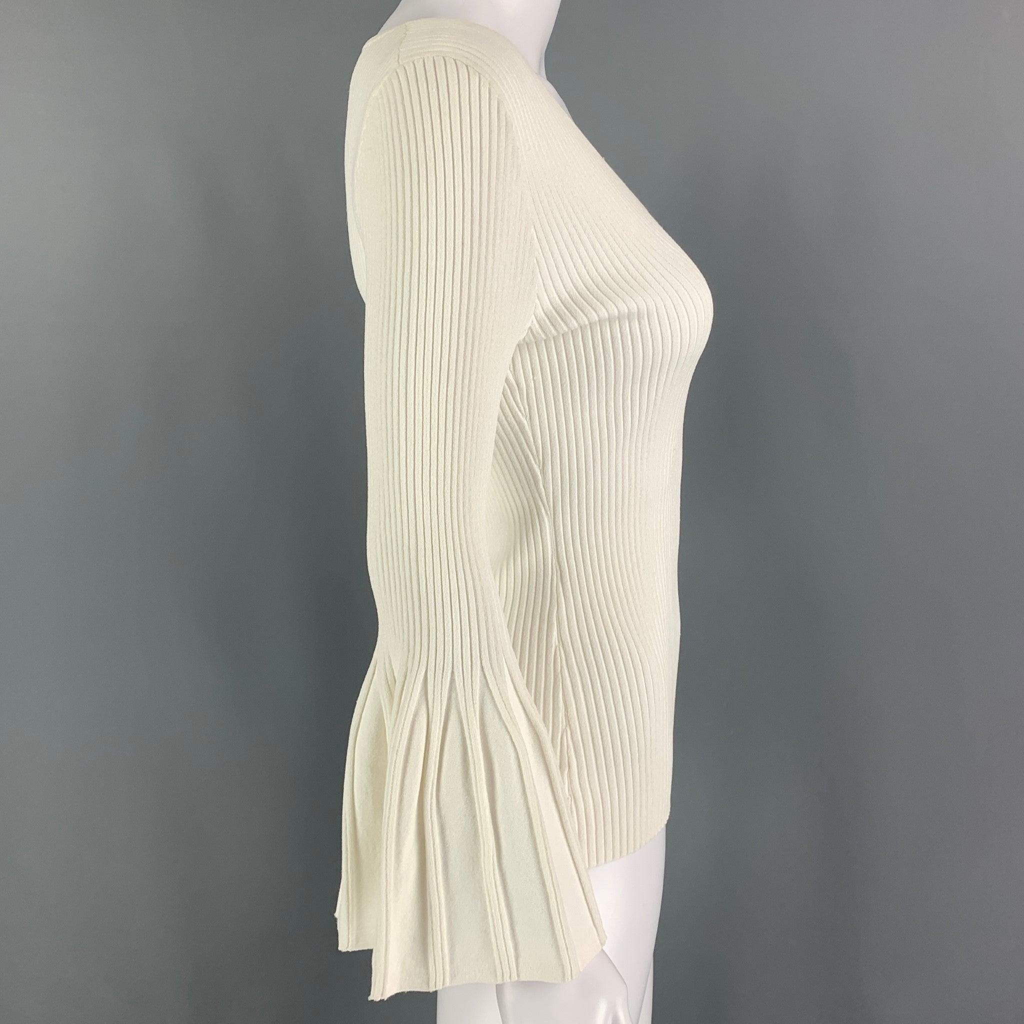 CAROLINA HERRERA top comes in a white stretch ribbed viscose / polyester featuring flared sleeves and a v-neck.
Very Good
Pre-Owned Condition. 

Marked:   M/M 

Measurements: 
 
Shoulder: 15 inches Bust:
26 inches Sleeve: 21 inches Length: 23 inches