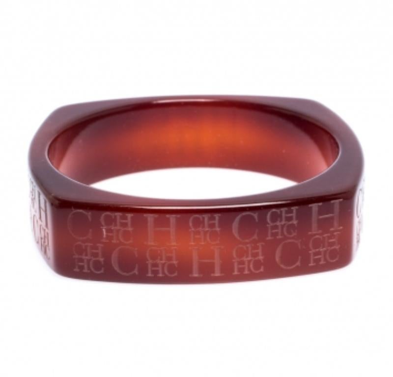 Semplicità e classe si combinano per formare A questo squisito braccialetto a bracciale largo di Caroline Herrera. Realizzato in resina marrone chiaro, presenta il logo CH su tutta la superficie.
