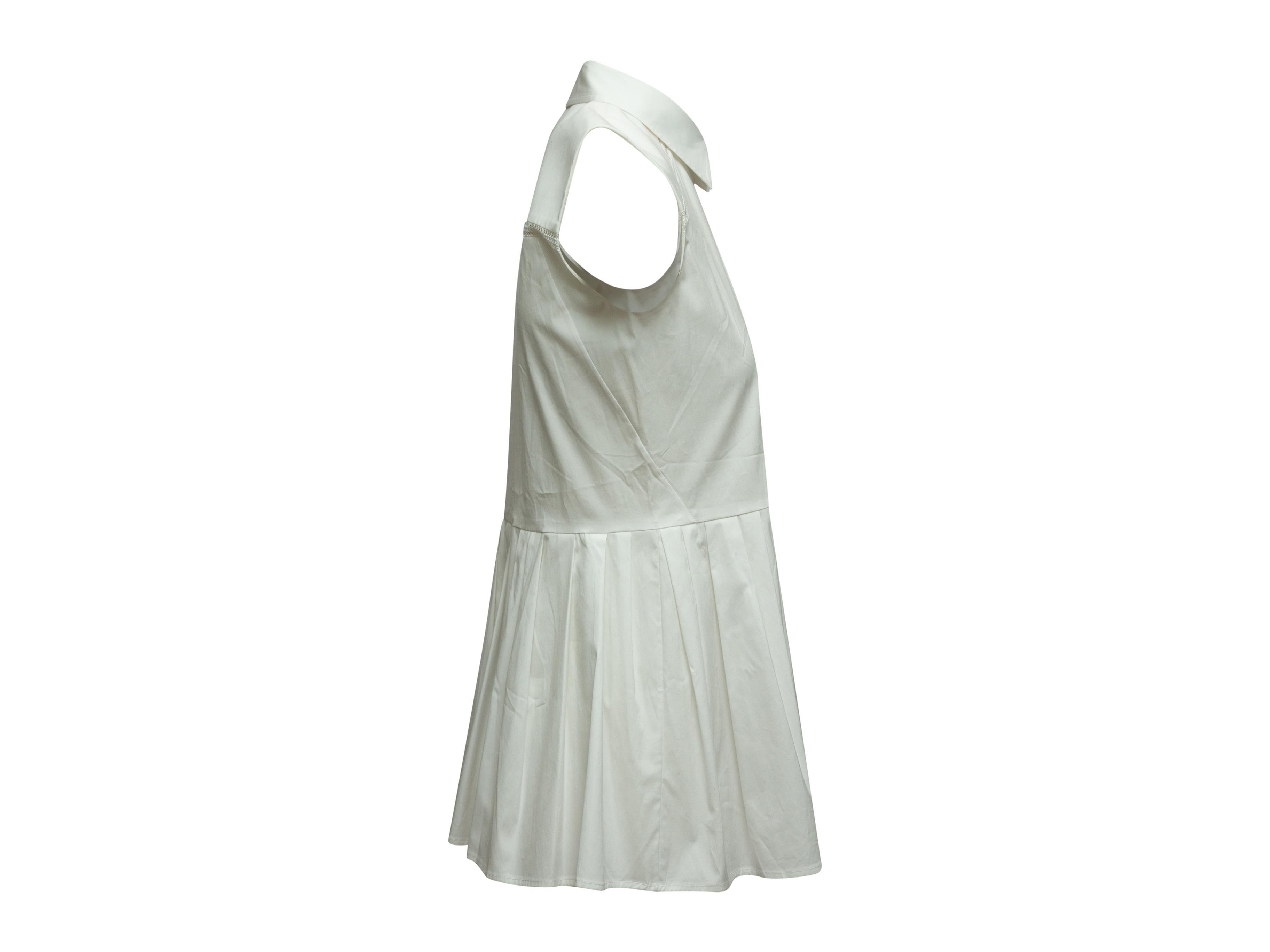 Product details: White sleeveless peplum top by Carolina Herrera. Pointed collar. Button closures at center front. 34
