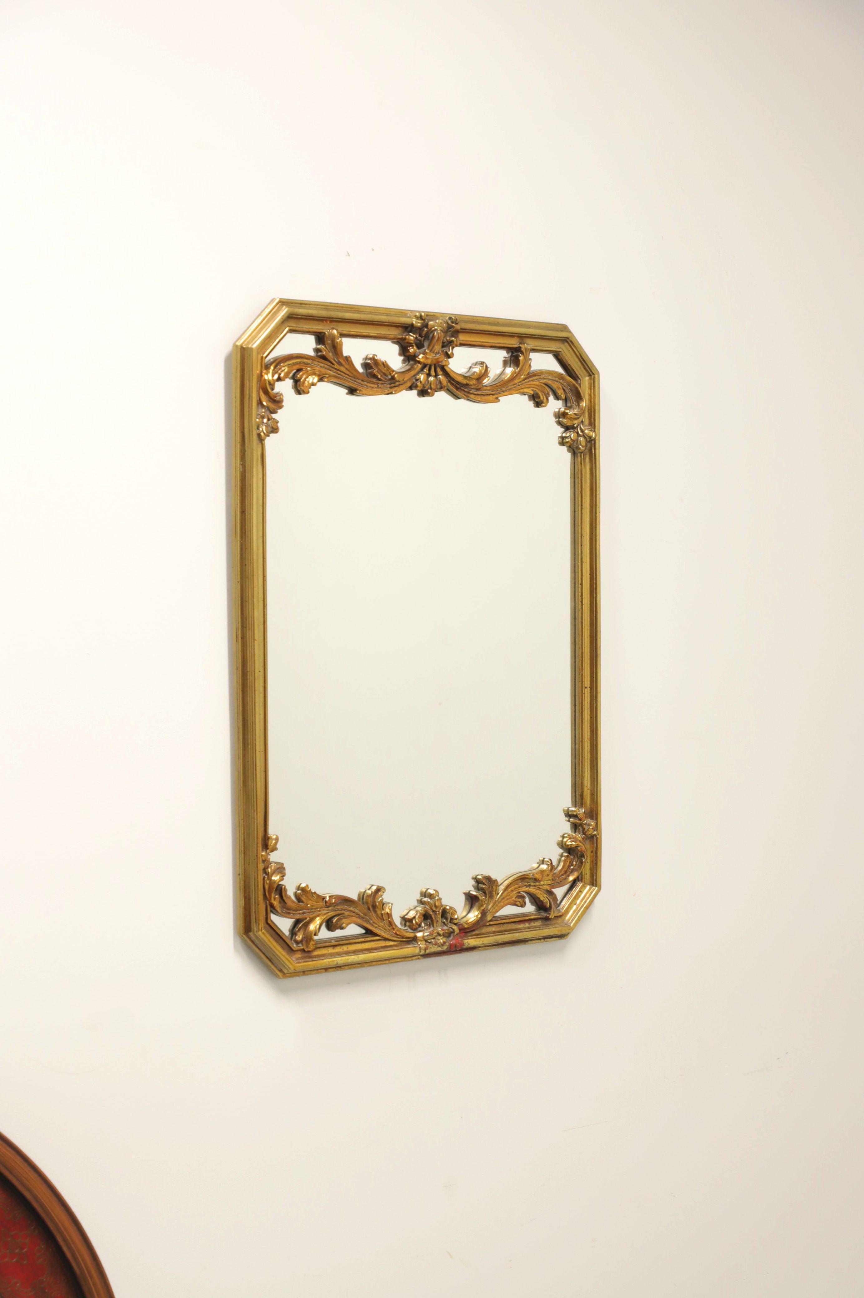 A Traditional style wall mirror by Carolina Mirror. Mirror glass in a hexagon shaped composite frame with decorative acanthus leaves to top and bottom, painted gold with accents of red to lend appearance of age. Made in North Carolina, USA, in the