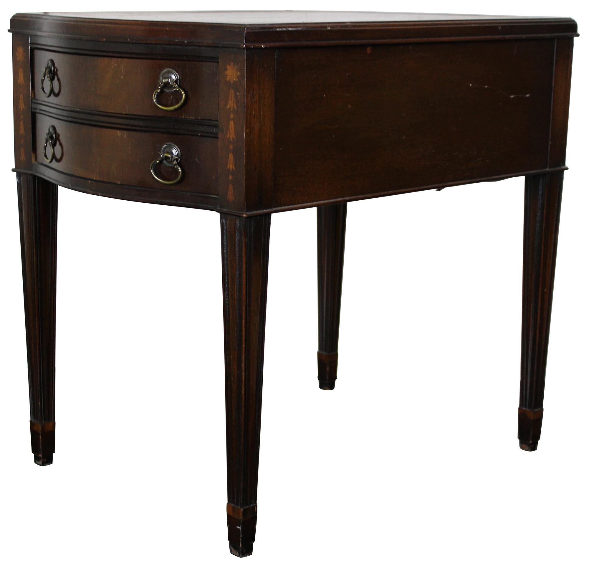 Midcentury Hepplewhite/ Sheraton end table. Made from mahogany with tooled leather top. Features a serpentine front of two dovetailed drawer and inlay. The table is supported by square tapered and fluted legs. Sold by F & R Lazarus & Co in Columbus