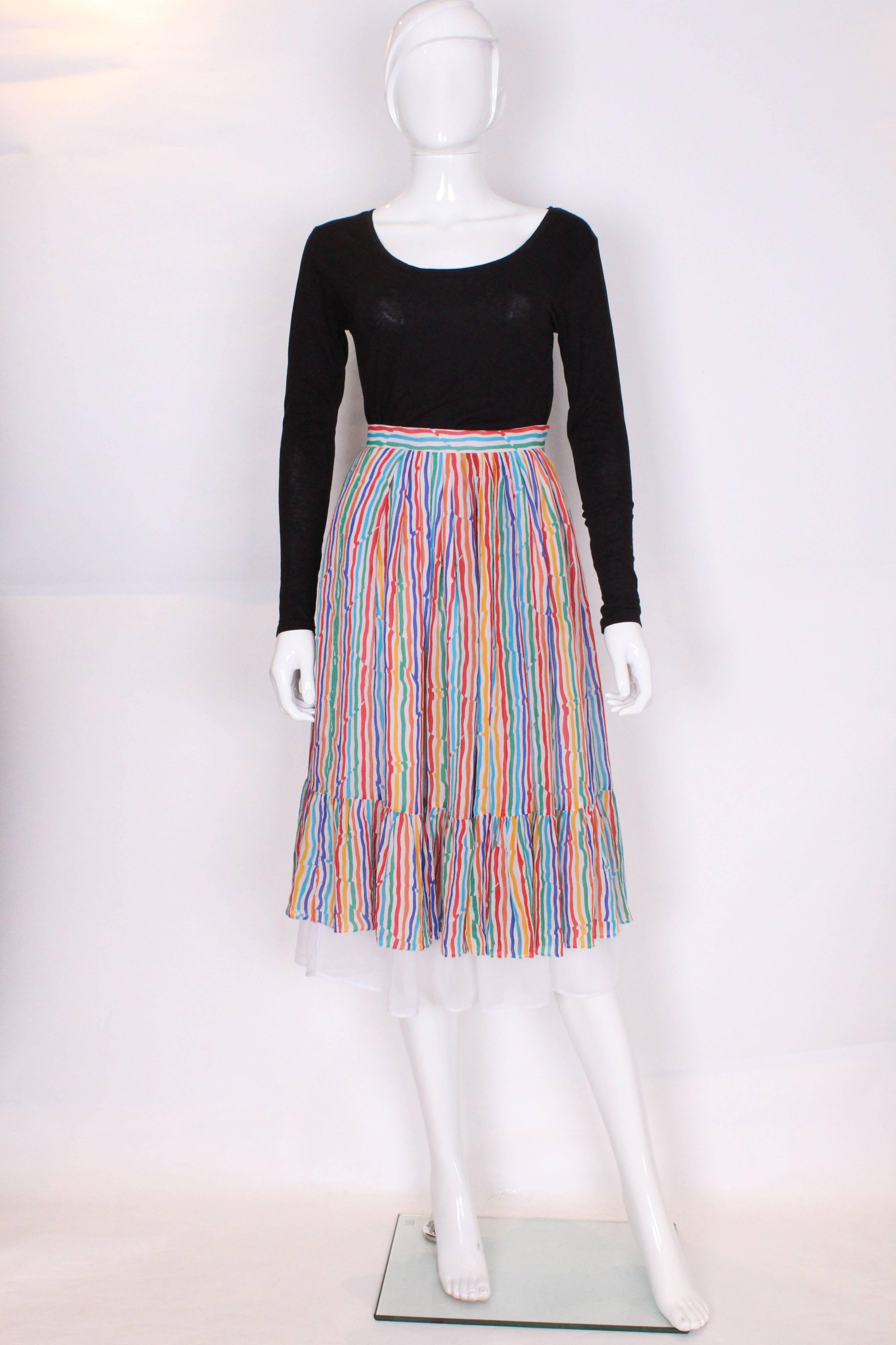 A colourful skirt by British Designer Caroline Charles, perfect for summer. The outer layer is  silk with a multi coloured stripe print. The waistband is made of the same fabric but with the stripes running horizontally, and there is a 7 1/2'' frill