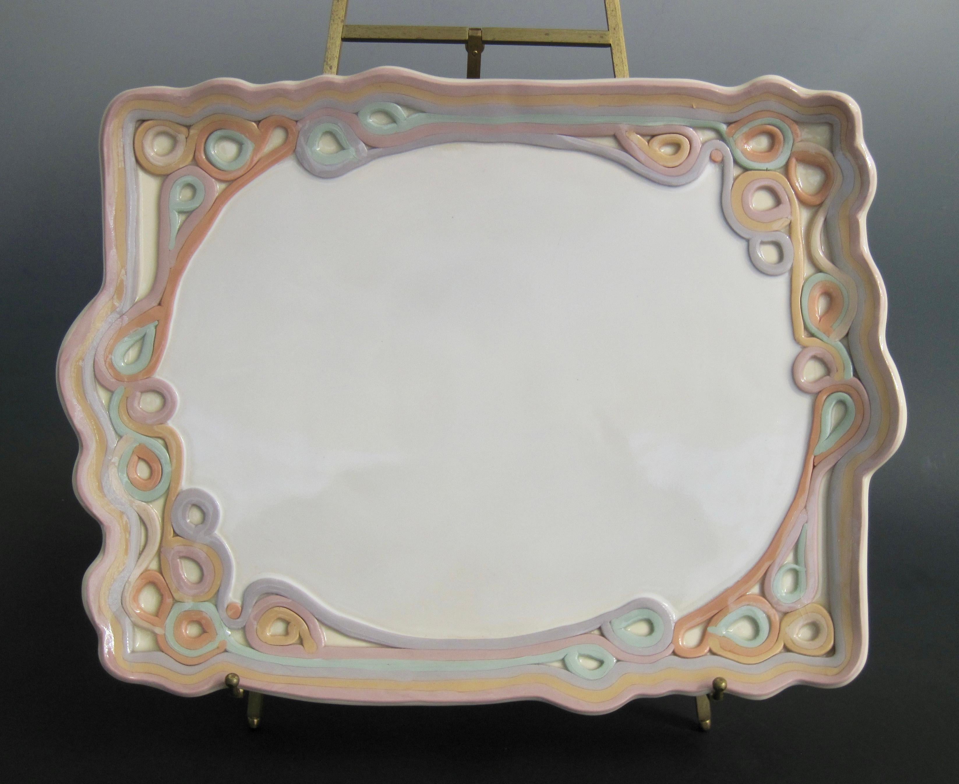Studio tray by Carolyn Leung, circa 1970s. Undulating pastel colored coils elegantly frame the oval white interior like a art nouveau mirror. Feminine and dreamy, perfect to hold perfumes in your boudoir or iced confections at tea. Signed on