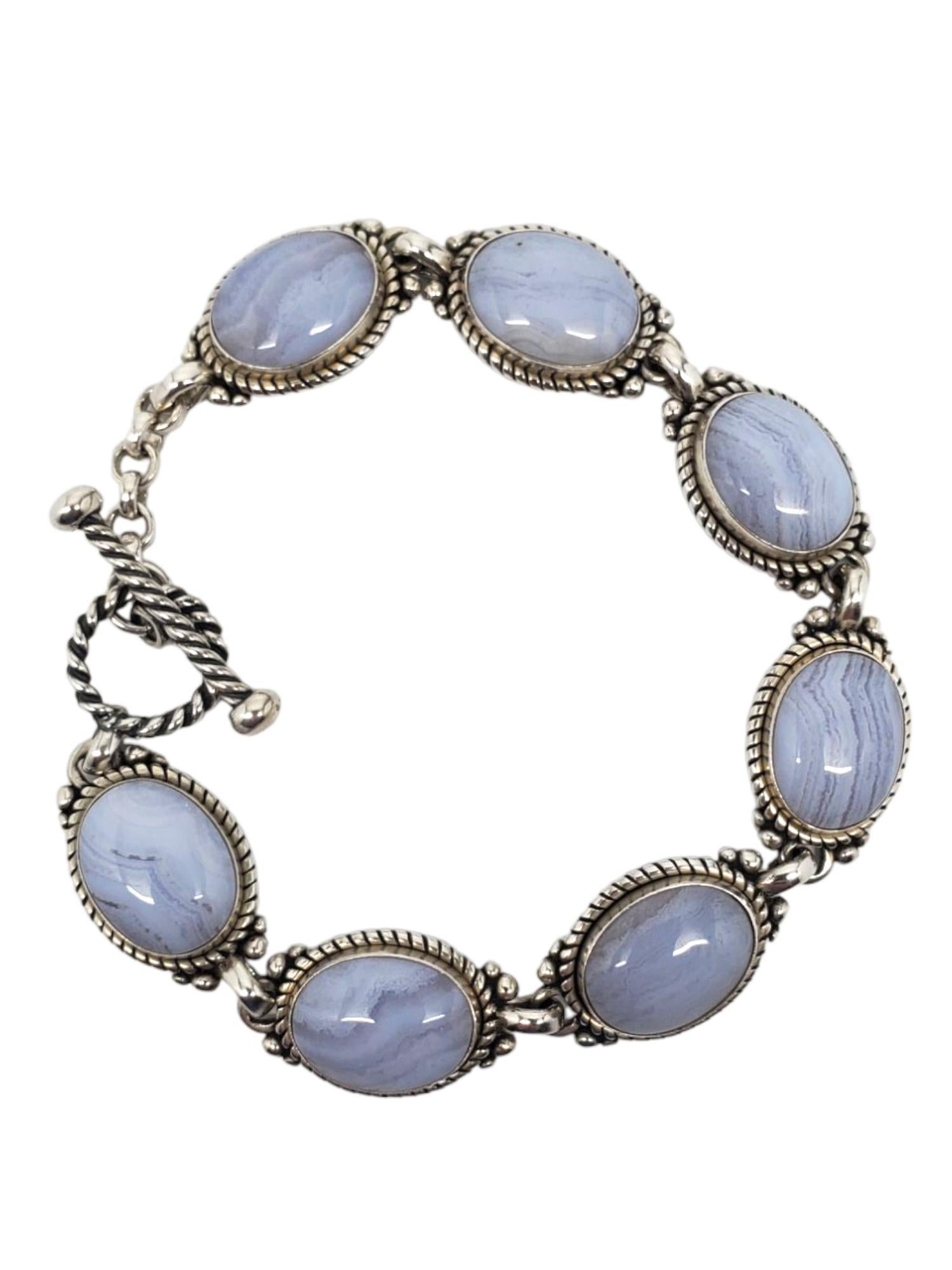 Bracelet en argent sterling Carolyn Pollack - Agate bleue en forme de dentelle

Ce magnifique bracelet à bascule de Carolyn Pollack présente 7 cabochons ovales d'agate bleue (10,7 mm x 13,9 mm) sertis dans un chaton à motif de corde portant
