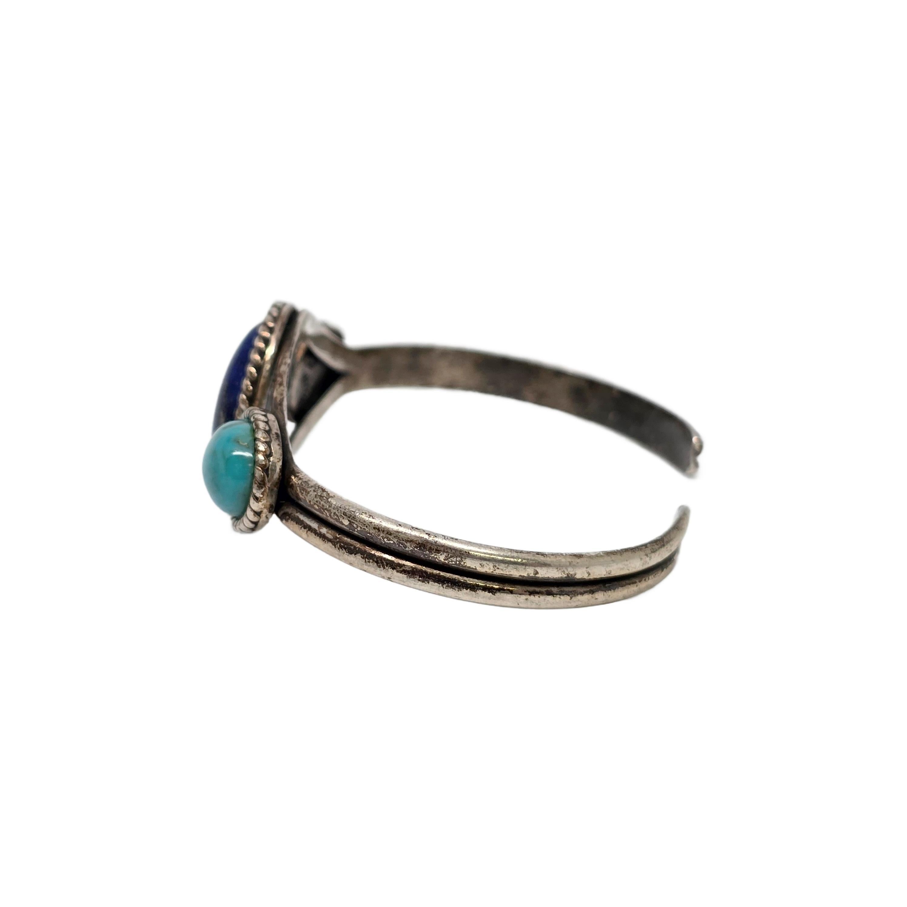 Bracciale in argento sterling con lapislazzuli e turchese di Carolyn Pollack.

Grande lapislazzuli ovale al centro, affiancato da due pietre di turchese azzurro, tutte e tre incorniciate da una cornice in corda ritorta.

Pesa circa 15,7 g, 10,1