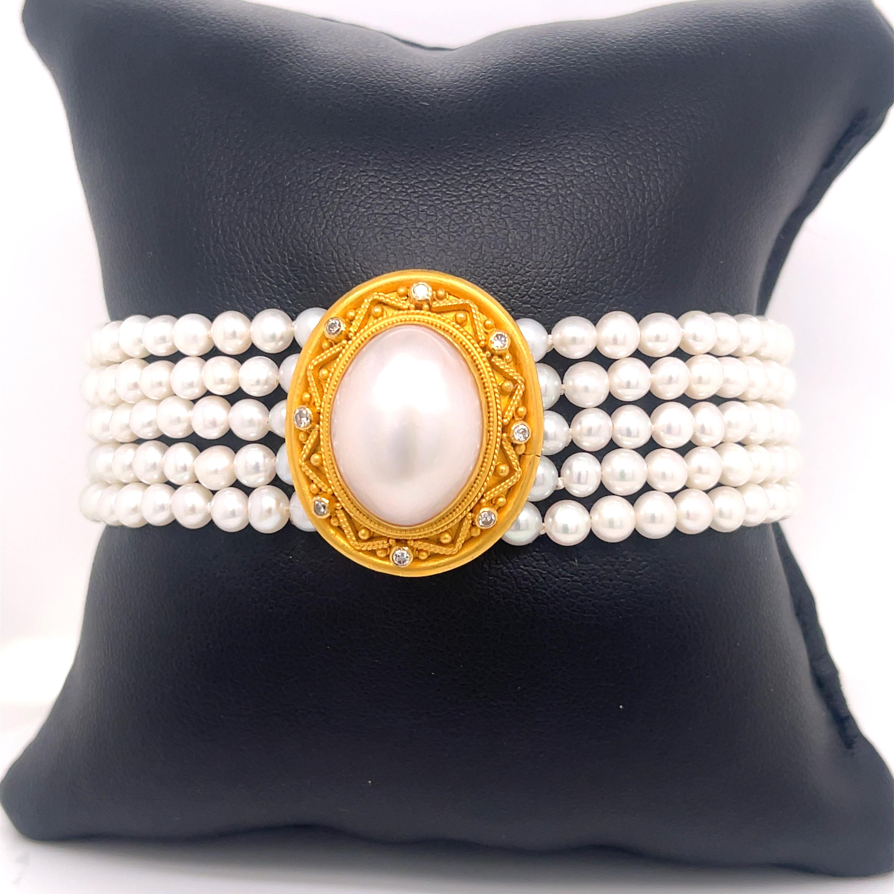 Carolyn Tyler pearl and diamond bracelet in 22K gold. The bracelet features five strands of pearls on each side, with an oval mabe pearl in the center framed by eight diamonds. Stamped 22k C TYLER INDONESIA 2909. 