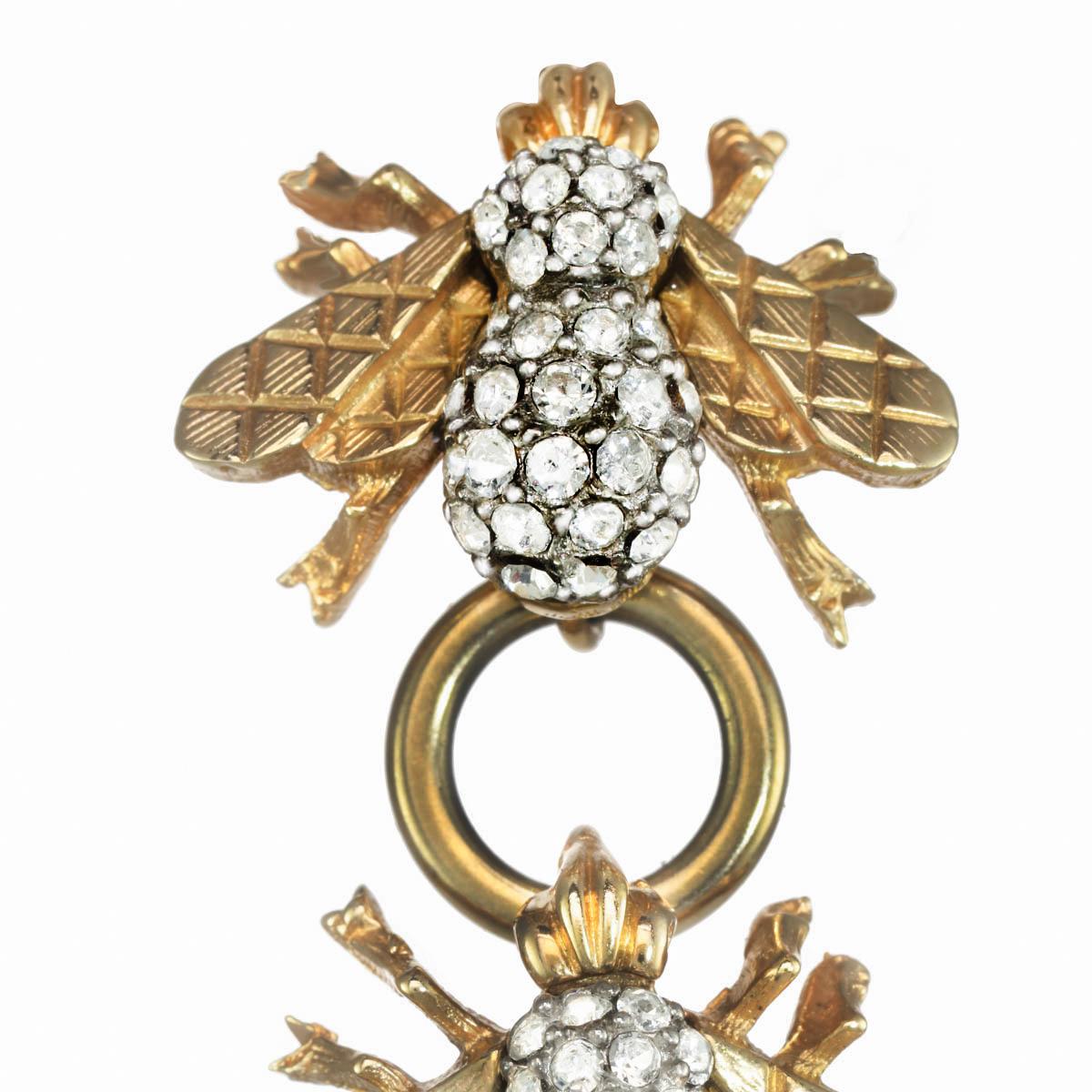 Four CINER heritage bees, with polished gold connectors, encompasses this gorgeous linear statement earring. With beautifully detailed gold quilted wings and illuminating Swarovski crystal rhinestone accents, these earrings are Carolyne's take on an