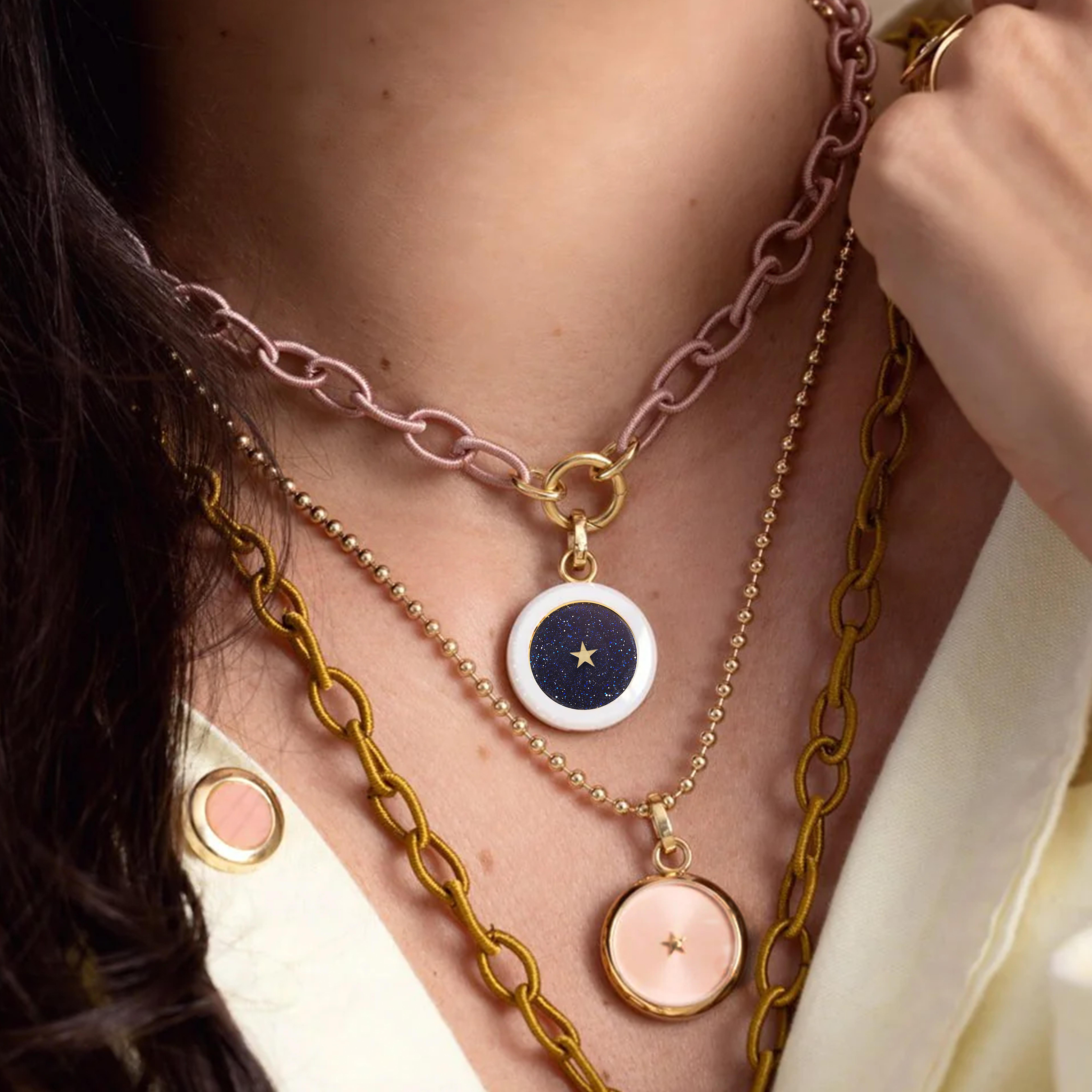 An innovative pendant with a white ceramic and golden titanium case, featuring an 18kt yellow gold openable clasp. 
Carpe Diem pendant contains a clock movement that brings life to a little 6 point golden star, a constant reminder of the precious