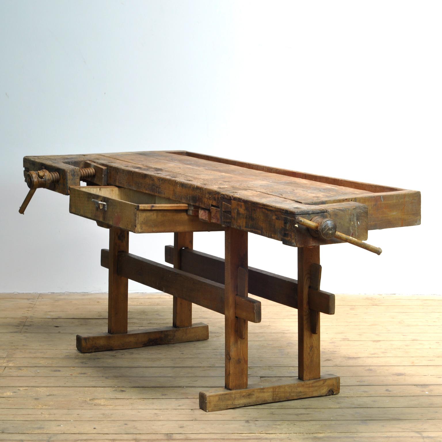 This antique workbench has two built-in wooden vices screws and a recessed tray where the carpenter would put his tools. It was manufactured around 1900. Made from oak. Beautiful patina after years of use. Really nice details in the contruction. The