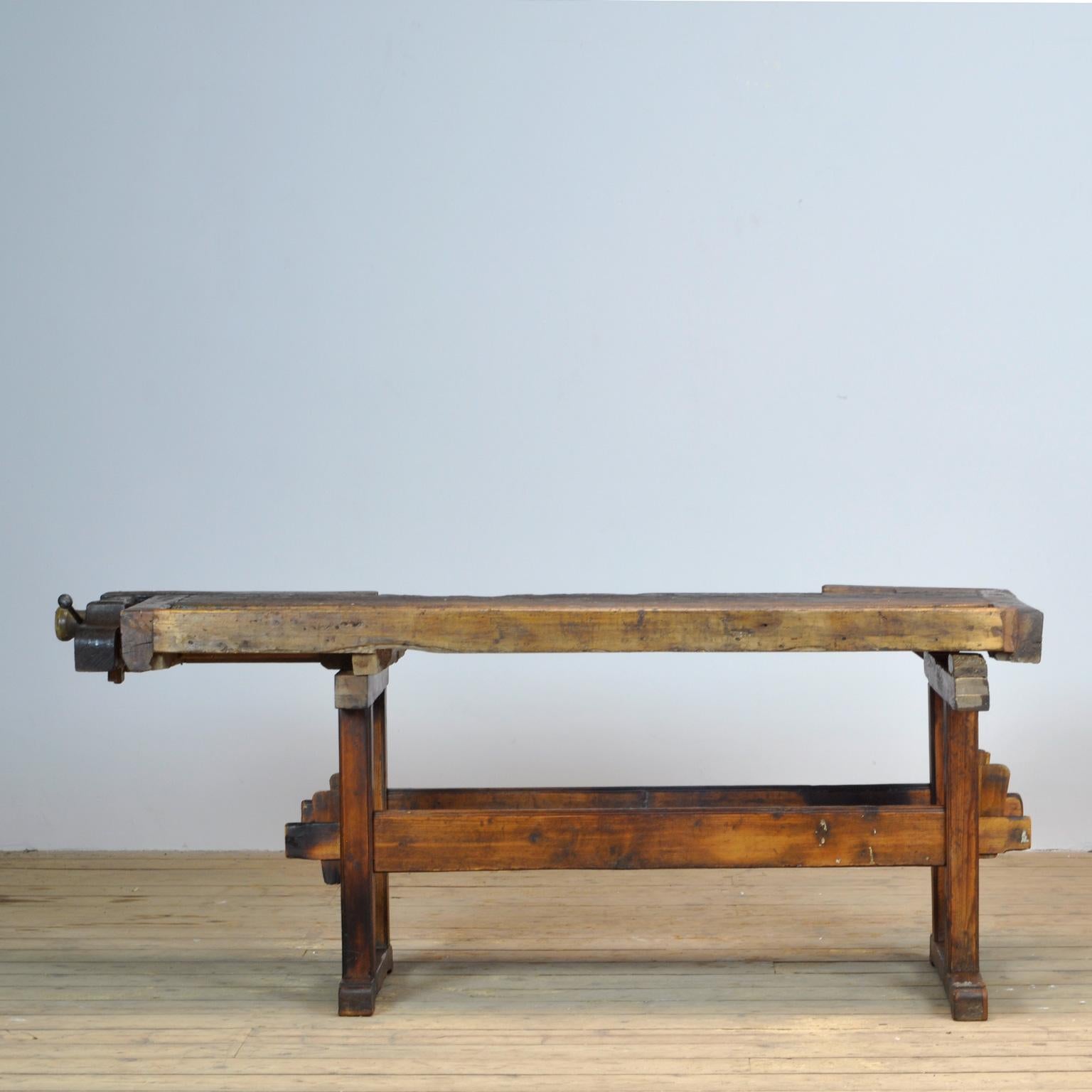 This antique workbench has two built-in vices screws and a recessed tray where the carpenter would put his tools. It was manufactured circa 1920. Made from oak with a pine base. Beautiful patina after years of intensive use. The workbench has been
