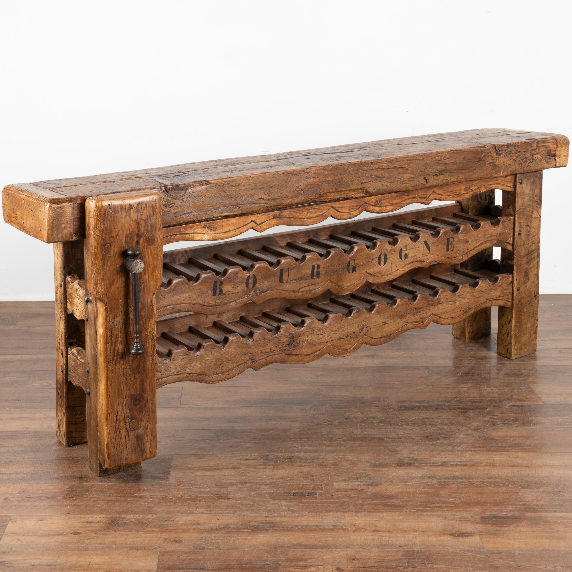It is the years of constant use revealed in every ding, gouge, deep crack, and scratch that enrich the character of this impressive carpenters' workbench from France.
Unique to this console is the (newer) two shelves serving as a wine rack; simple