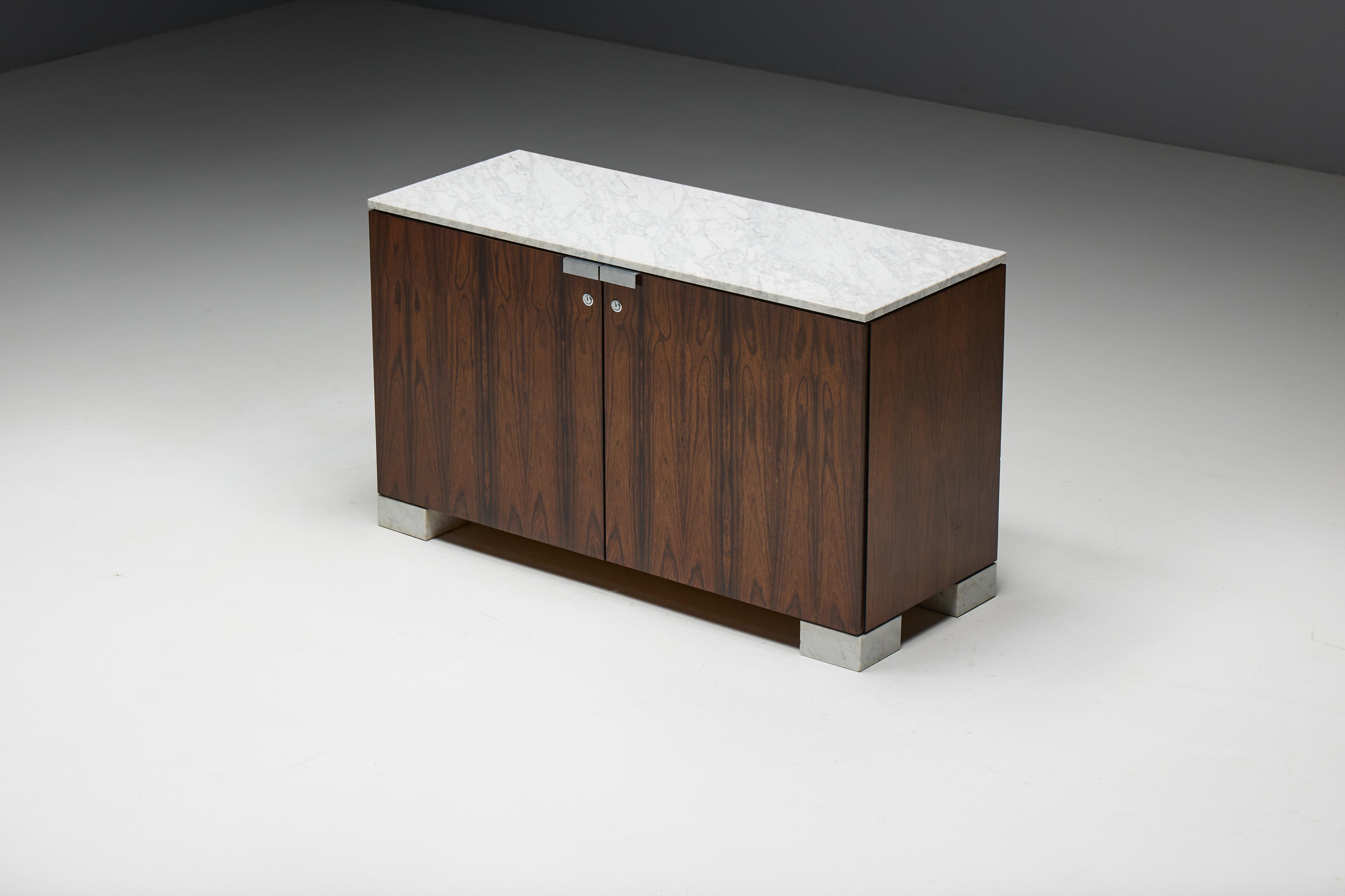 Armoire raffinée des années 1960 par De Coene Frères, un bel exemple de l'artisanat belge du milieu du siècle. Son riche placage de bois de rose apporte chaleur et sophistication, magnifiquement complété par un plateau en marbre de Carrare. Le