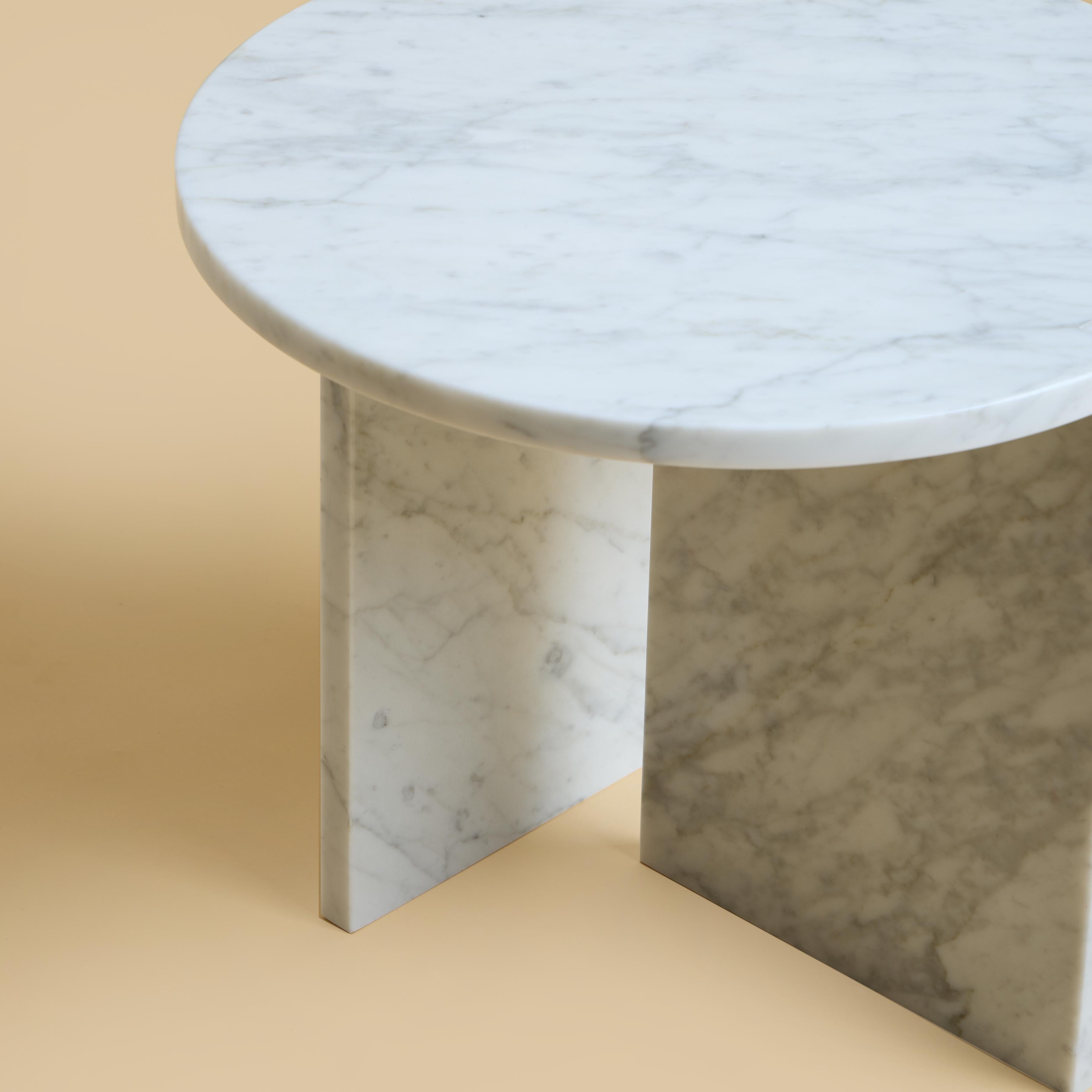 Der Kyushu Couchtisch ist komplett aus Carrara-Marmor gefertigt. Die Platte ist rund und hat einen Durchmesser von 45 cm, die Beine bestehen aus zwei Marmorplatten, von denen ein Teil als elegantes Detail in die Platte eingelegt ist.

Das Stück