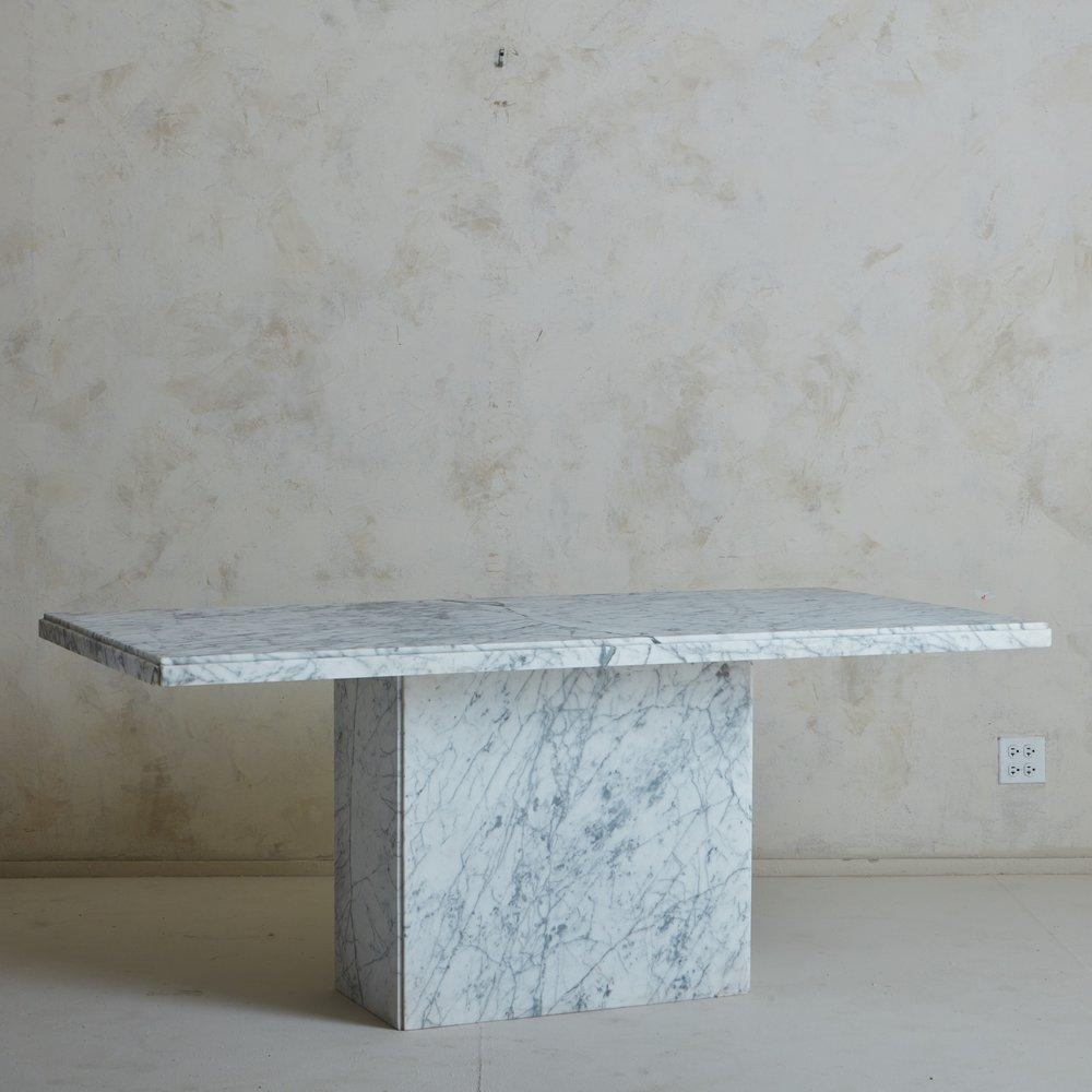 Table de salle à manger italienne des années 1970, avec un plateau rectangulaire à bord ogival et une base à piédestal. Cette table a été fabriquée en marbre de Carrare avec de magnifiques veines grises. Provenance : Italie, années 1970.