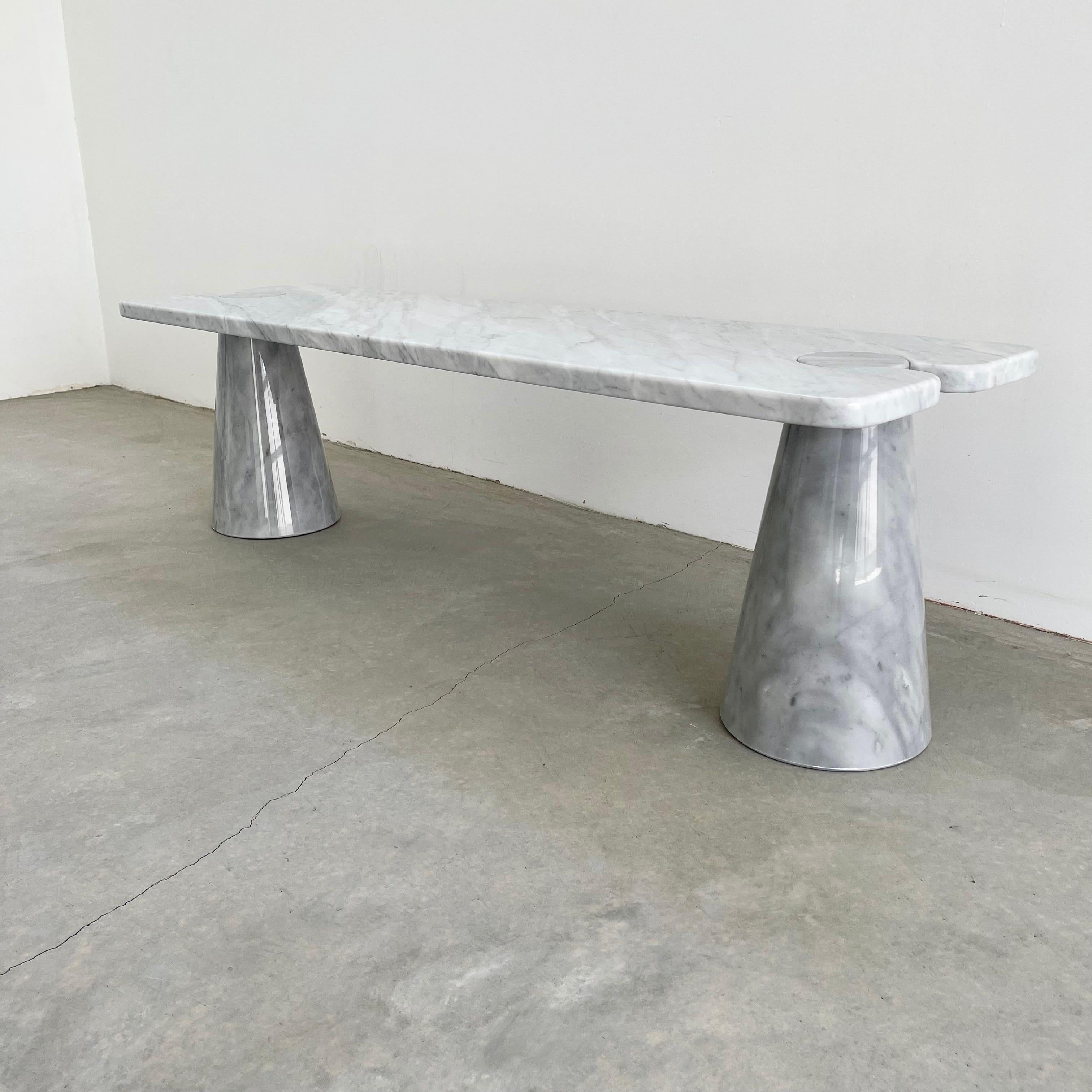 Stunning Carrara marble coffee table attributed to Angelo Mangiarotti. Large cone shaped bases hold a large slab of marble with circular cut outs. Extremely heavy and well made. Strong enough to be used as a bench if desired. White and blue/grey