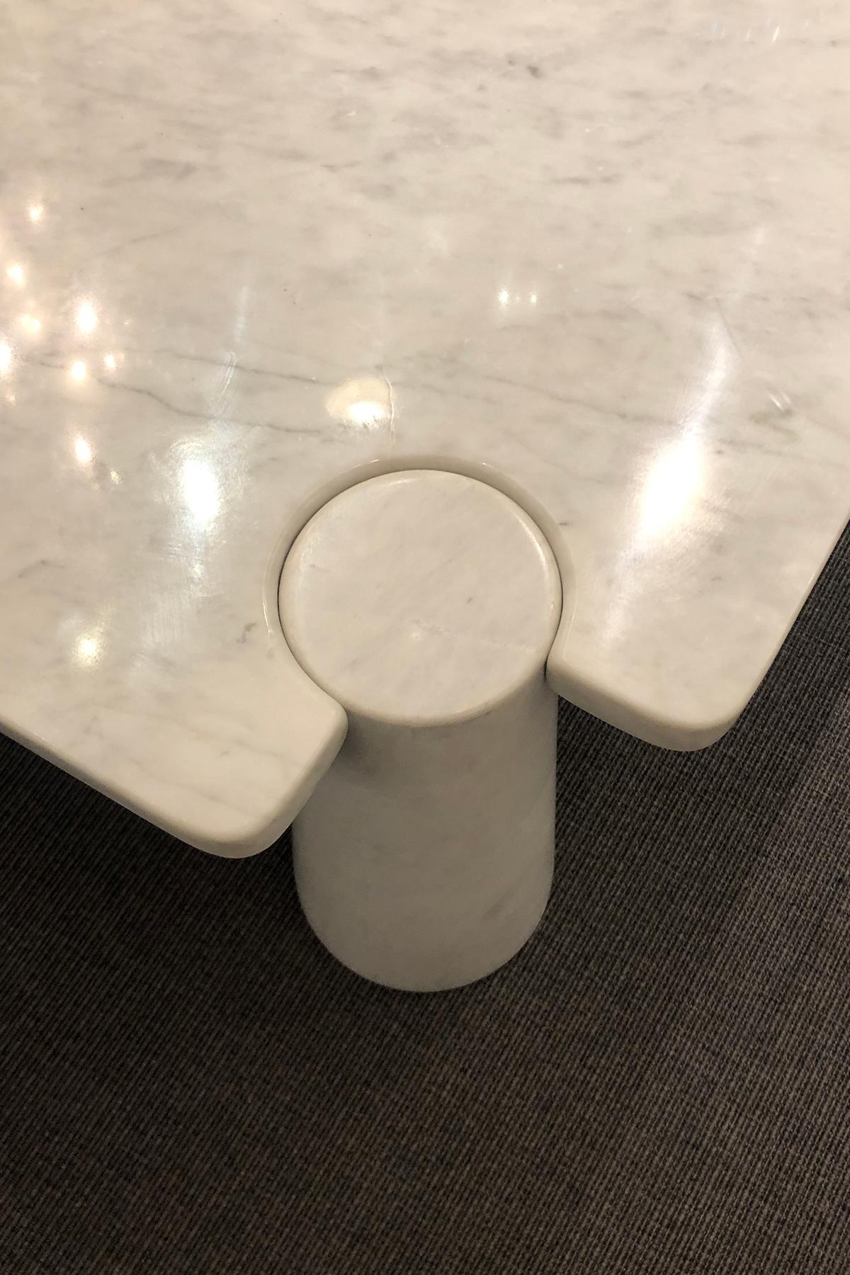 Rectangular coffee table in white Carrara marble, the top raised on a conical leg in each corner.