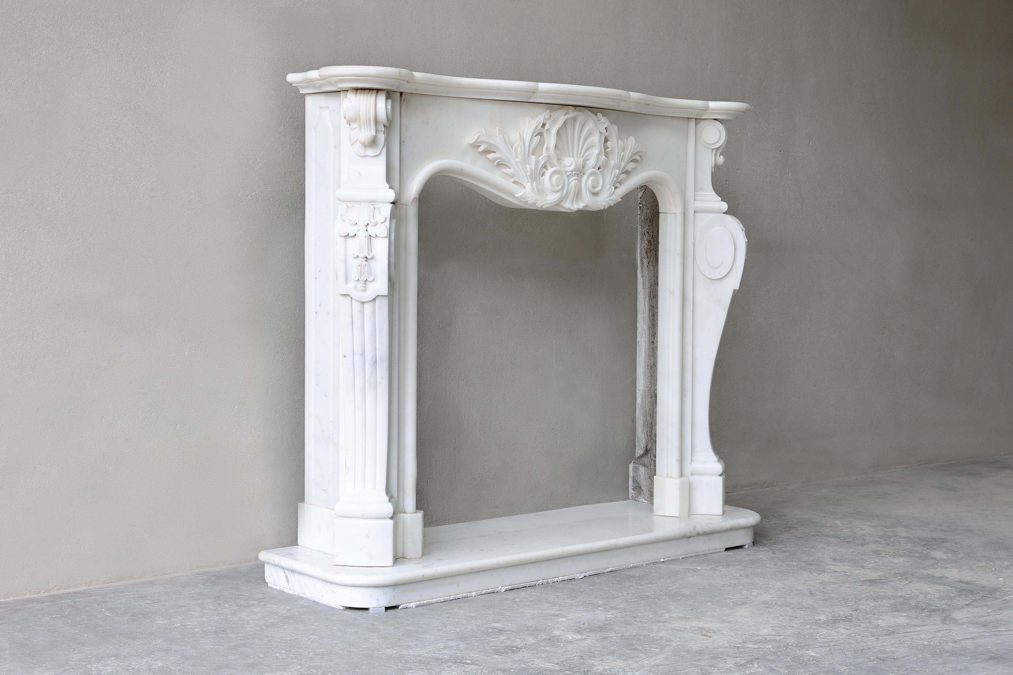 Beautiful fireplace of Carrara marble from Italy. This 20th century mantle features elegant ornaments and decorations. A graceful Louis XV style mantle that would fit perfectly in a classic or contemporary home.