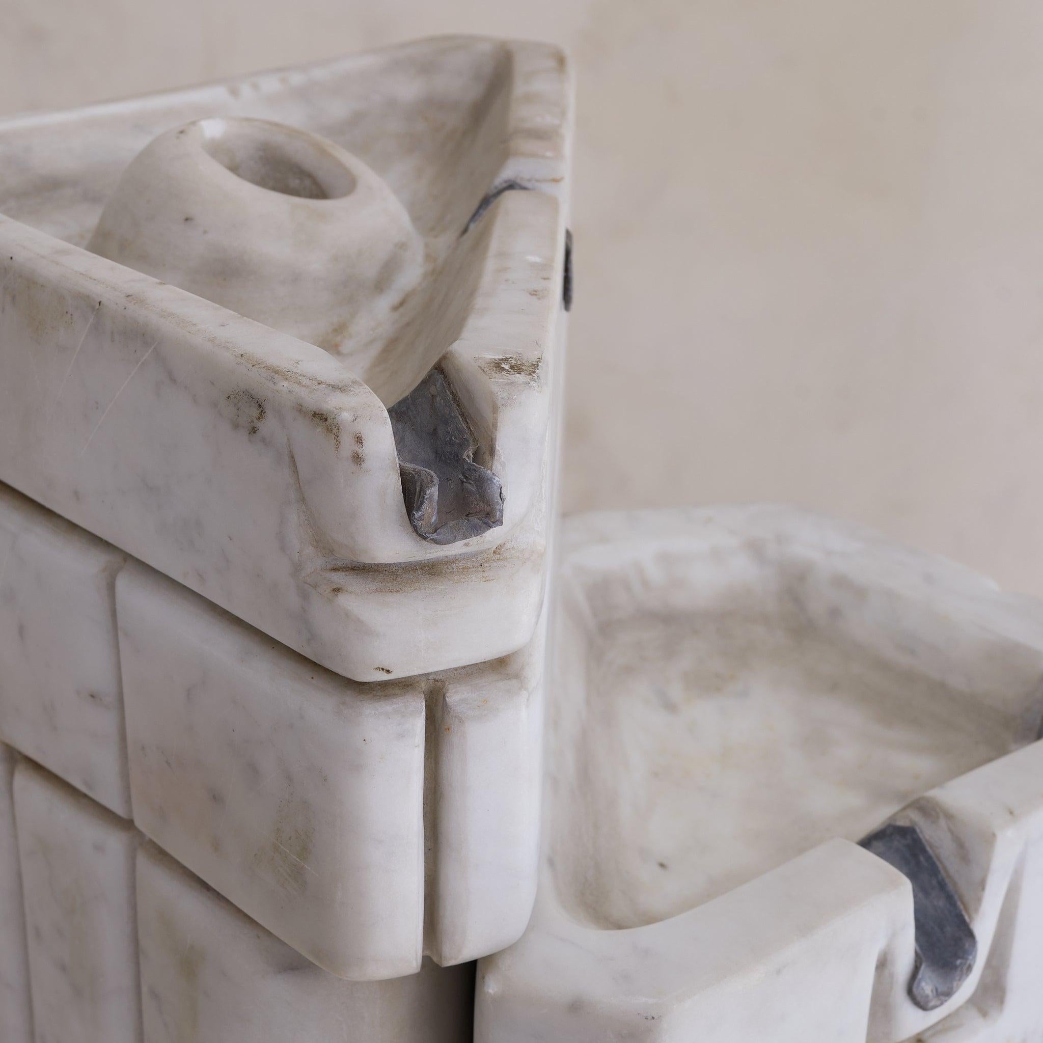 An embodiment of sculptural fluidity, this two-piece Carrara marble fountain dates to the 1980s and evokes the aesthetic of German sculptor Paul Brandenburg. Carved from solid Carrara marble, its smooth, interlocking forms suggest movement and