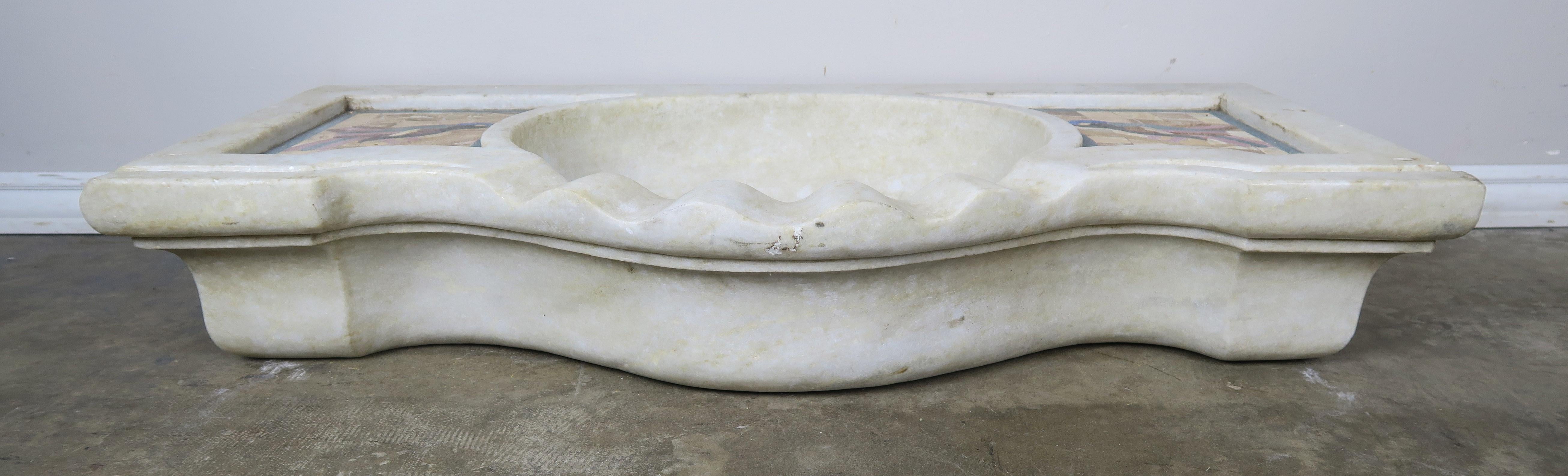Unique Serpentine shaped front Carrara marble sink that has been beautifully inlaid with birds on either side in soft hues of golds & taupes with touches of pink, blue, green and black in the bodies of the birds.