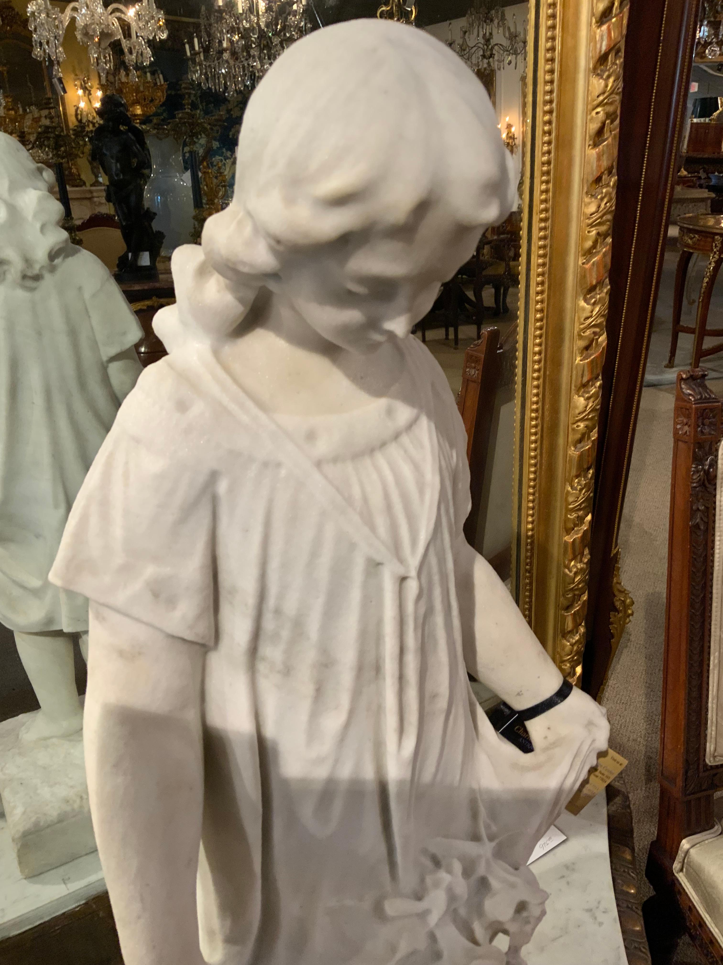 Diese Skulptur aus feinem Carrara-Marmor stellt einen jungen Mann dar, der
Barfüßiges Mädchen, das einen nach unten gefalteten Blumenstrauß hält
ihres Rocks. Er ist sehr weiß und ohne Flecken oder Absplitterungen. Keine Restaurierungen 
