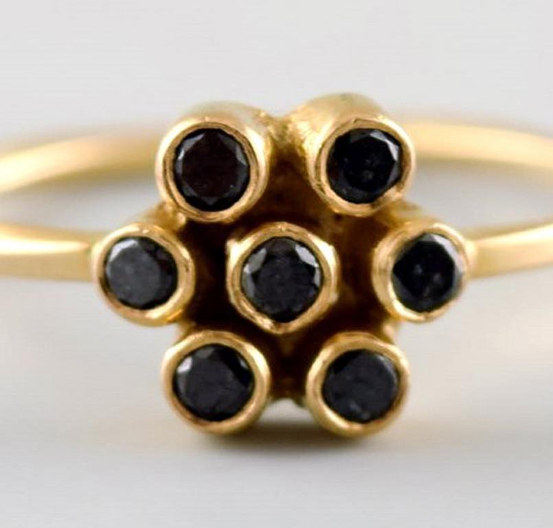 Modernist Carré ring in 18 kt. gold in the form of a flower. Adorned with 7 black diamonds