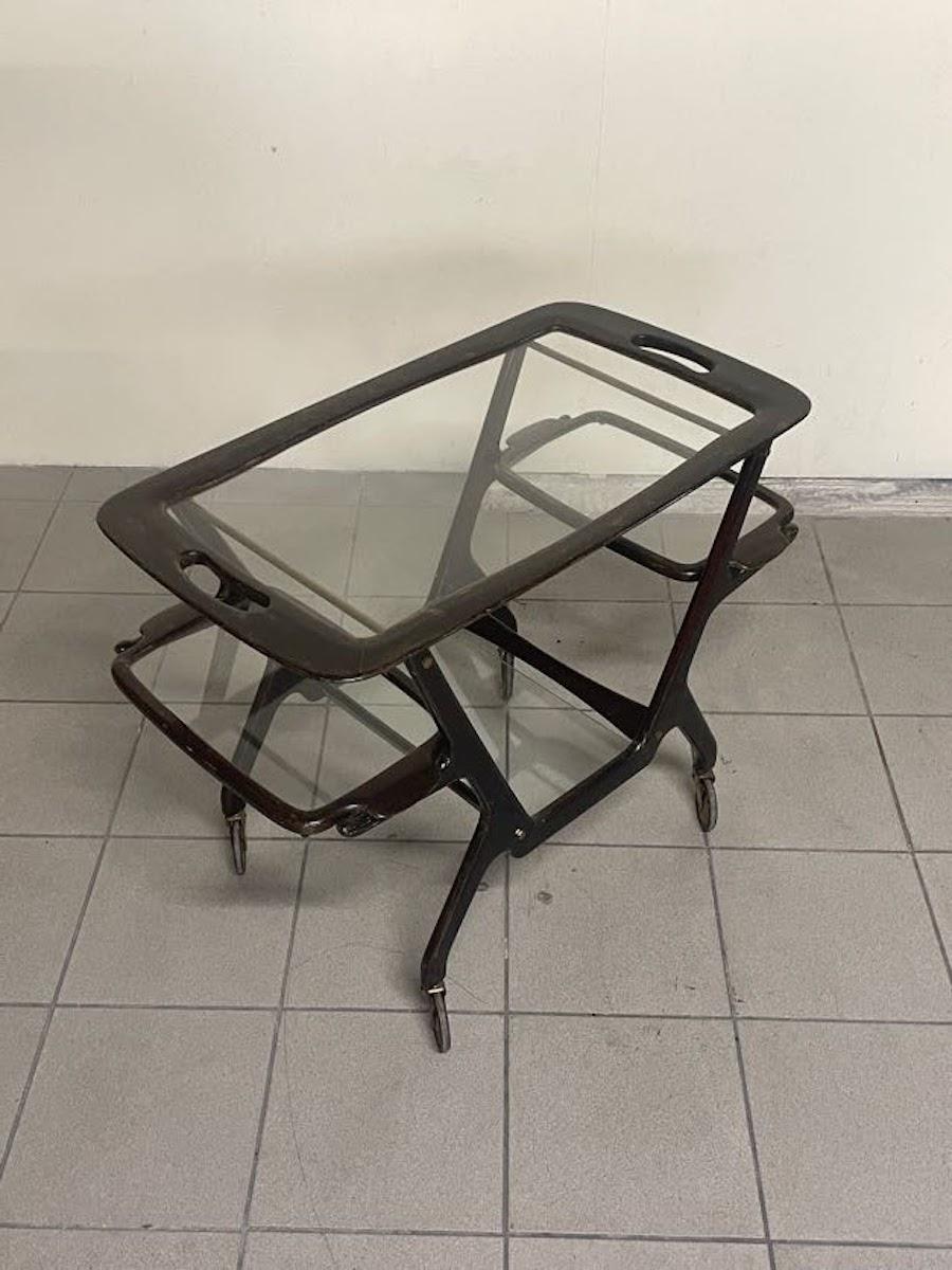 Sofisticato carrello bar italiano disegnato da Cesare Lacca, realizzato negli anni '50. 
La struttura è in legno e mette in risalto le linee eleganti tipiche della lavorazione artigianale di Lacca. 

Il carrello è dotato di tre vassoi removibili,