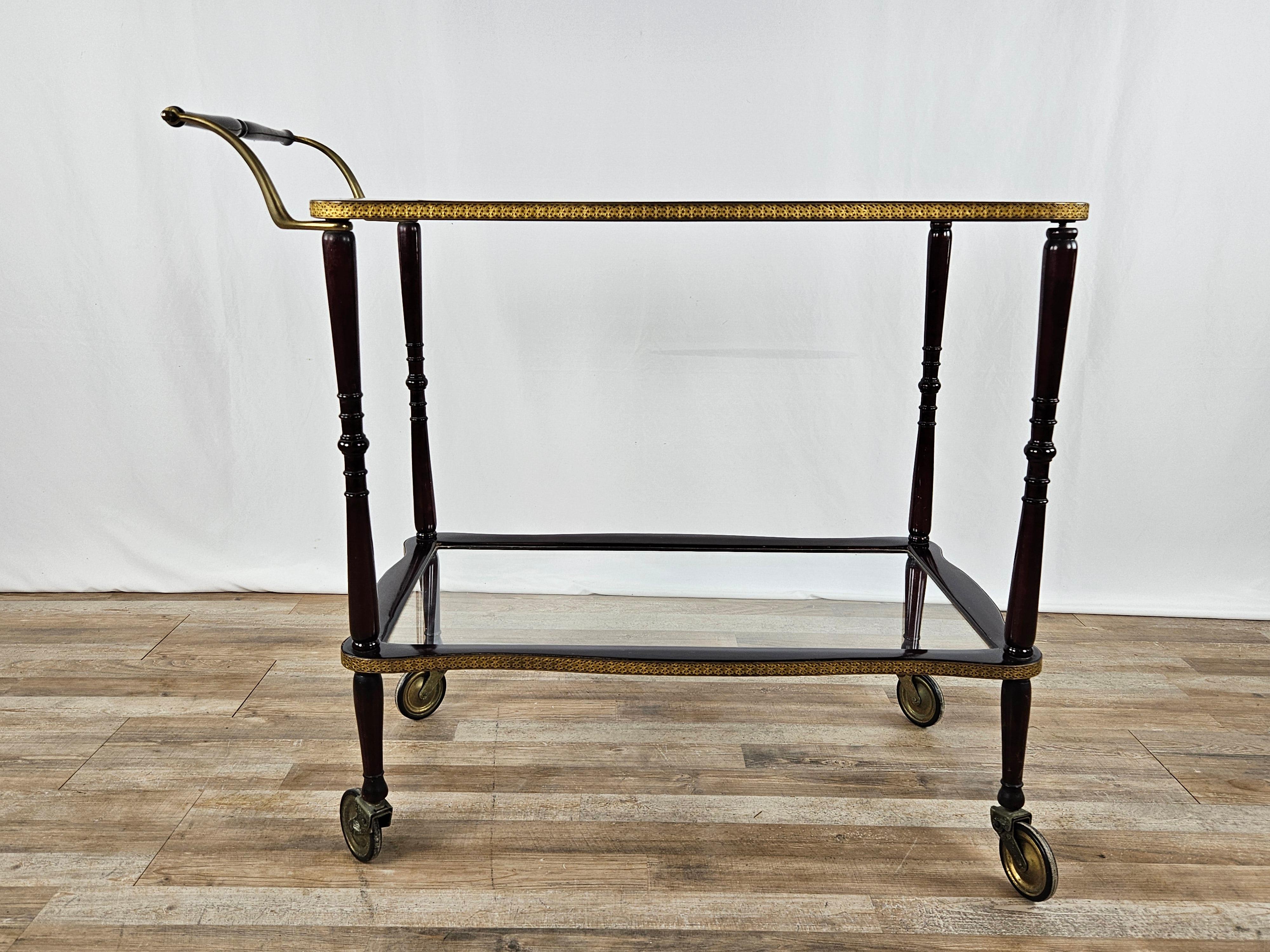 Rosewood bar cart and food rack with double clear glass shelf and a beautiful machined brass profile.

It has four wheels that are still fully functional and running.

Height from the ground of the first shelf 26cm
Height from the ground of the