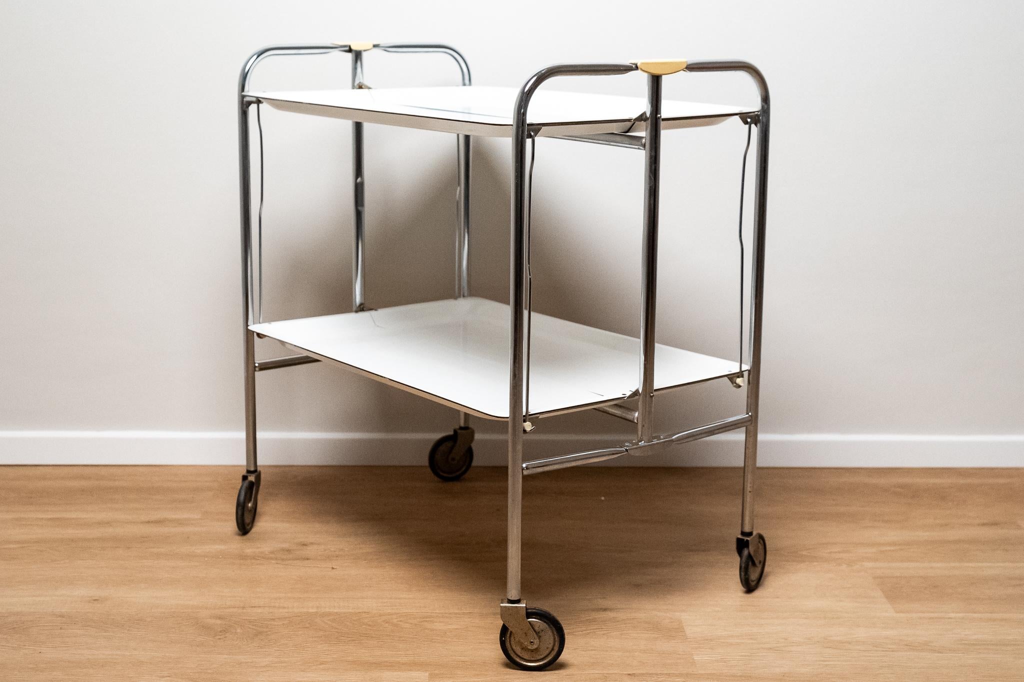 Chariot de bar ou de cuisine en plastique et métal chromé, fabriqué en Italie, années 1970. 
Chariot de bar ou de restauration pliable en plastique stratifié blanc / métal chromé. 
Tout est ORIGINAL et conserve la patine du temps. 
Il peut présenter