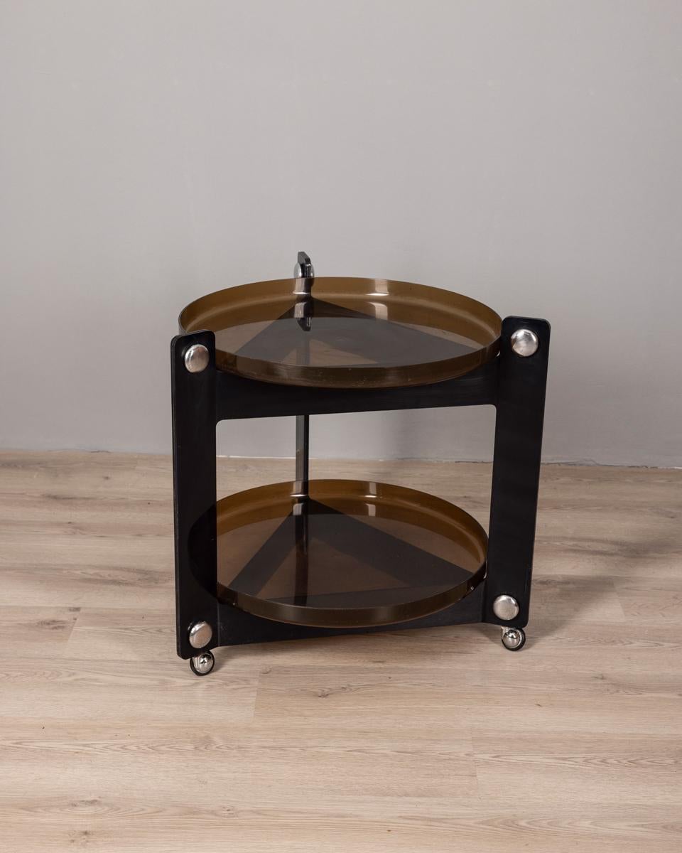 Carrello da bar in plastica fumè marrone con vassoi rimovibili, design Luigi Massoni per Guzzini, anni 70. E' compreso un set composto da 6 bicchieri, un portaghiaccio, una ciotola da punch con mestolo e 8 tazze, tutto marchiato