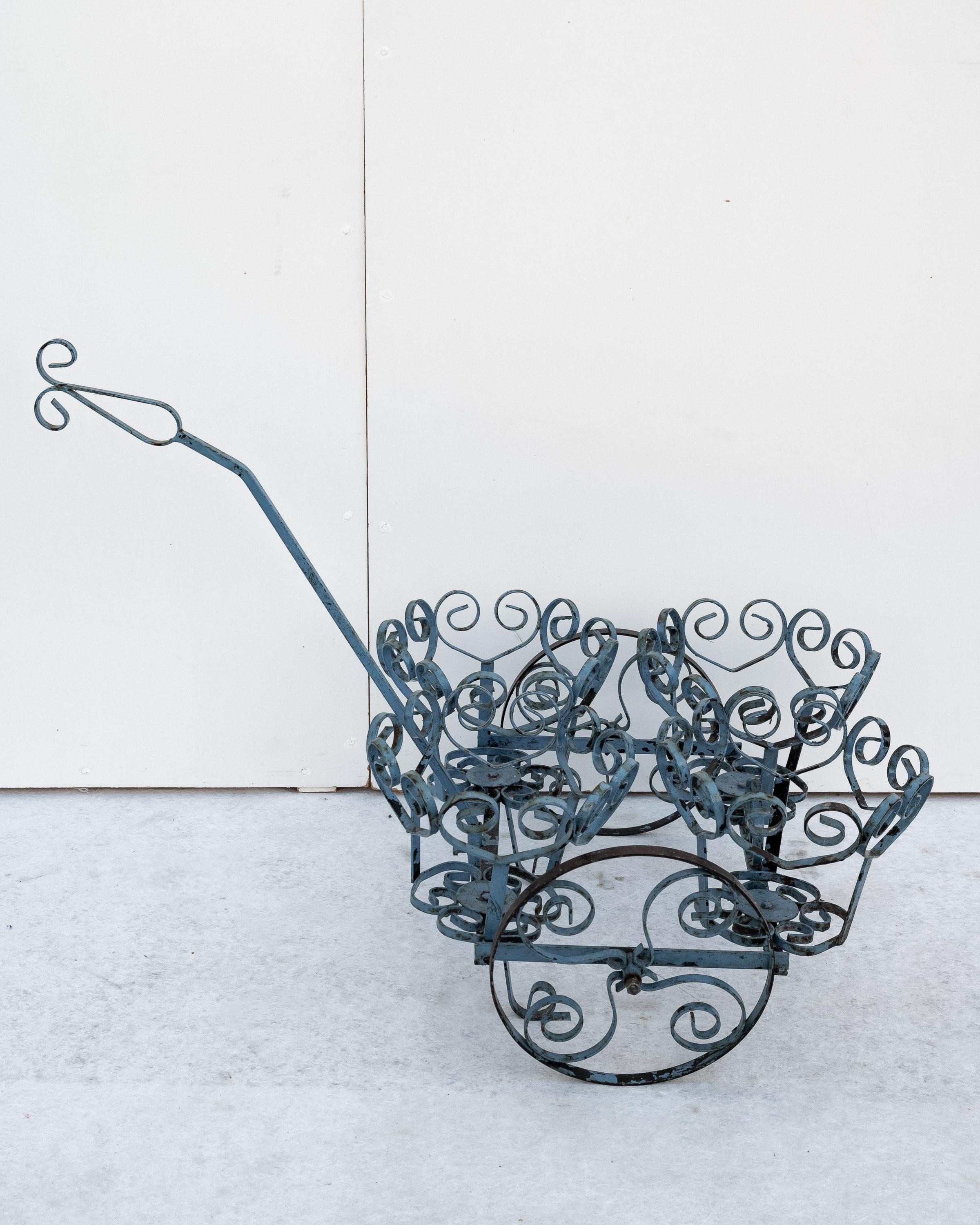 Carrello portavasi / fioriera in ferro battuto, Made in Italy, Anni '60. 
Straordinario Carrello portafiori in ferro battuto di colore celeste del periodo con patina originale. Ai lati del carrello di sono due ruote per agevolare lo spostamento. Le