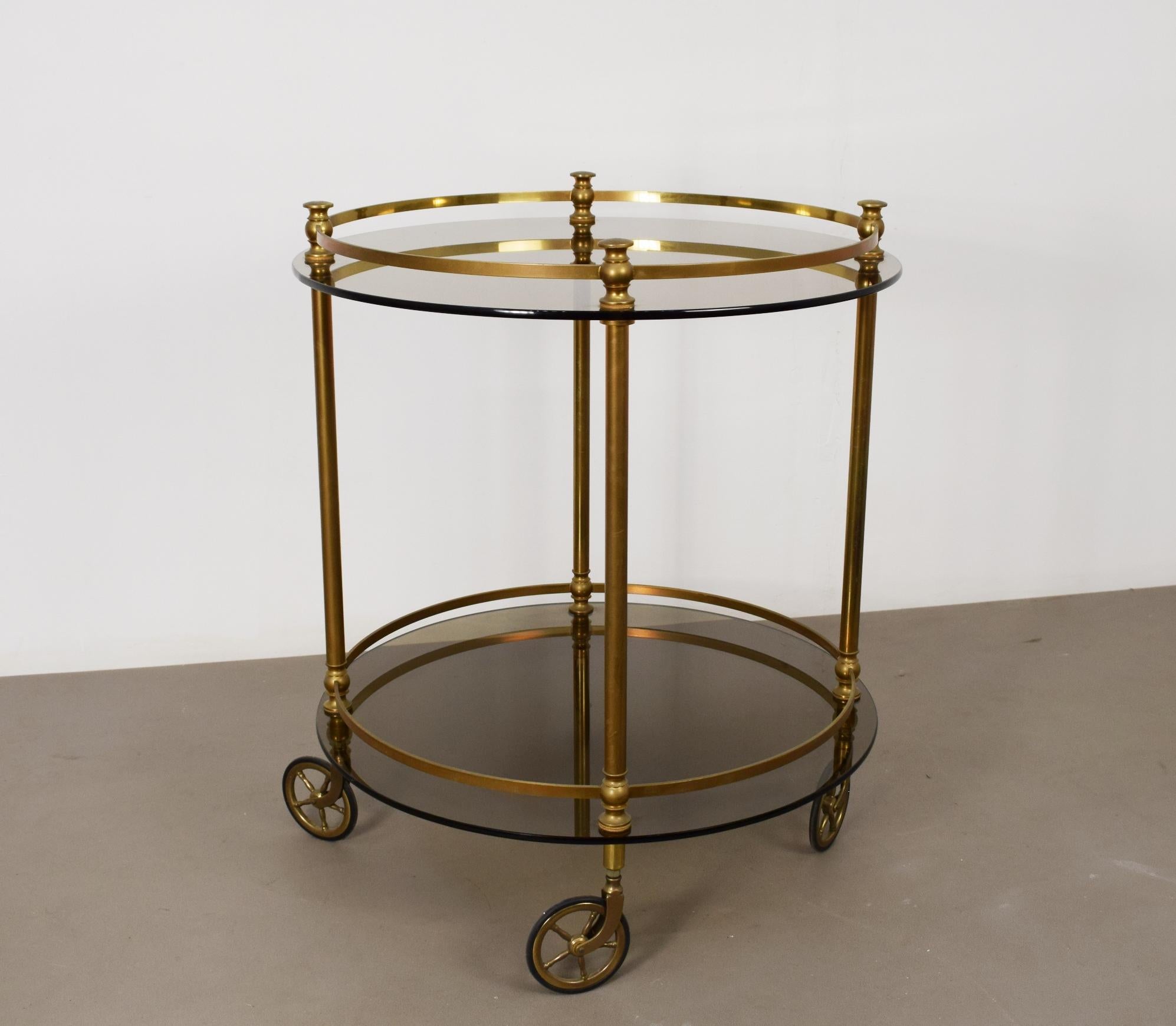 Chariot en verre fumé et cadre en laiton, production italienne vers les années 1960.
Lignes épurées, facilité d'utilisation, très utile pour servir des cocktails ou des plats.
Facilement transportable d'une pièce à l'autre grâce à ses roues