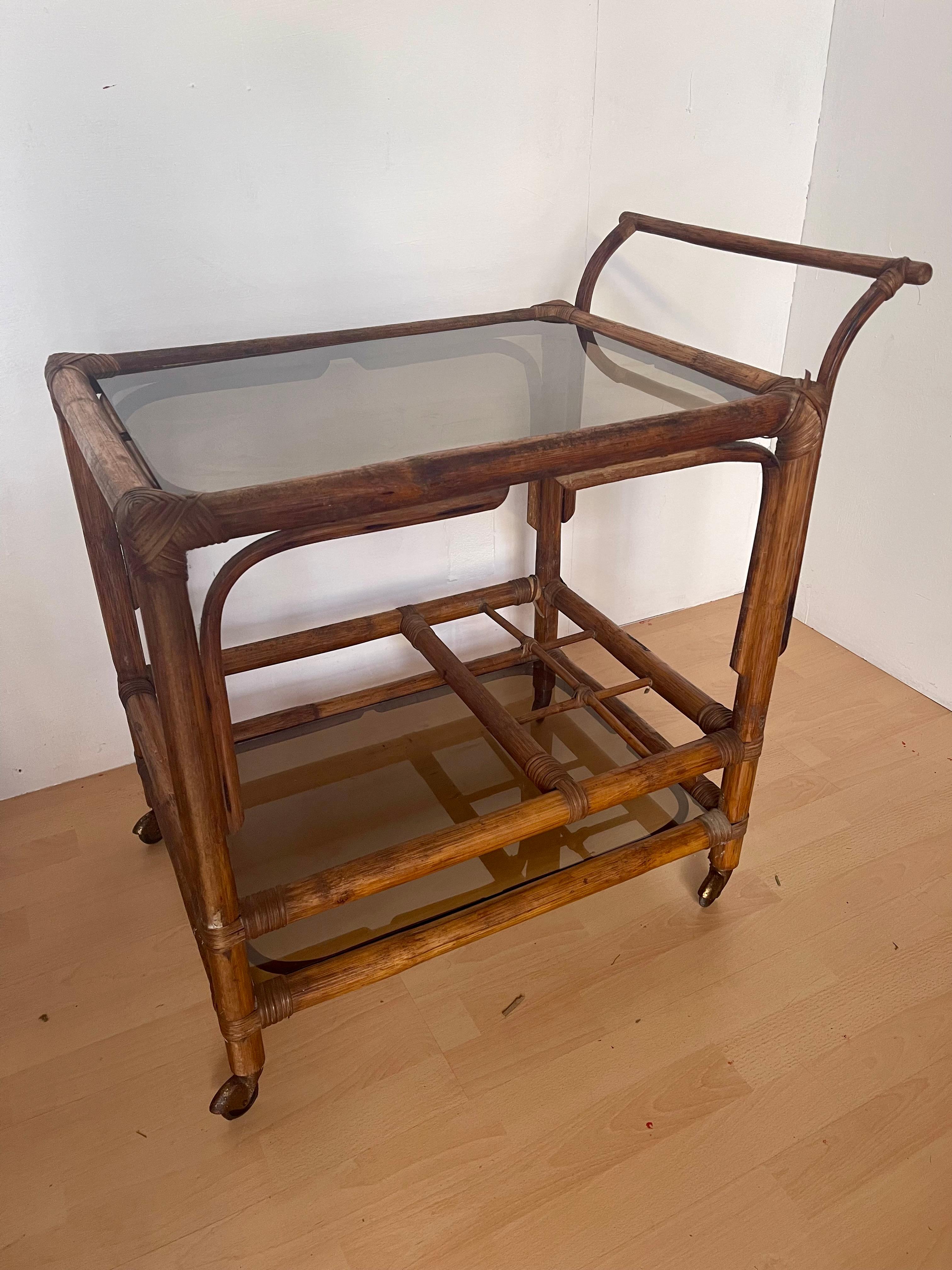 Italian Carrello portavivande italiano in legno di bengala e vetro fumé anni '70 in vendita