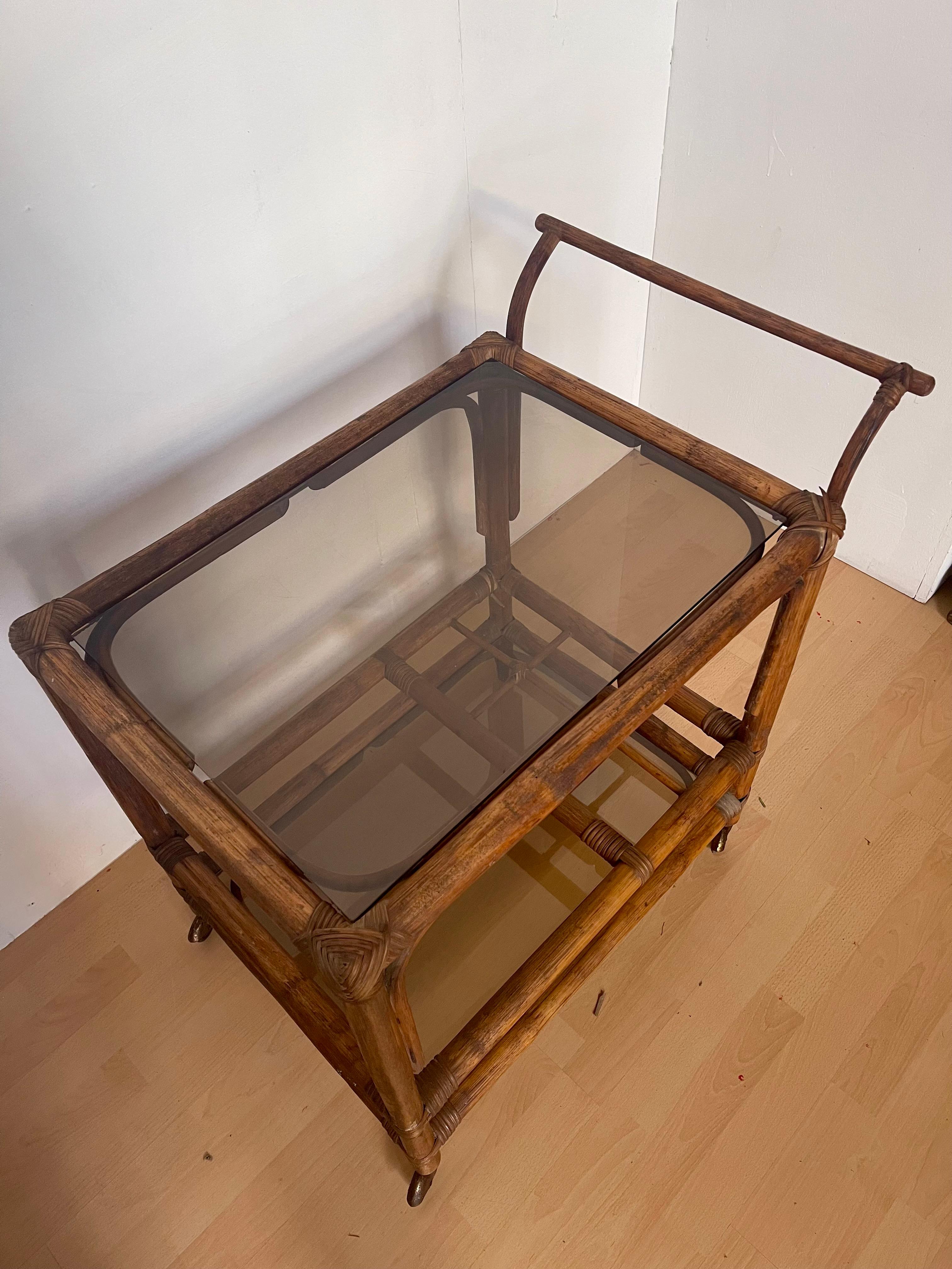 Legno Carrello portavivande italiano in legno di bengala e vetro fumé anni '70 in vendita
