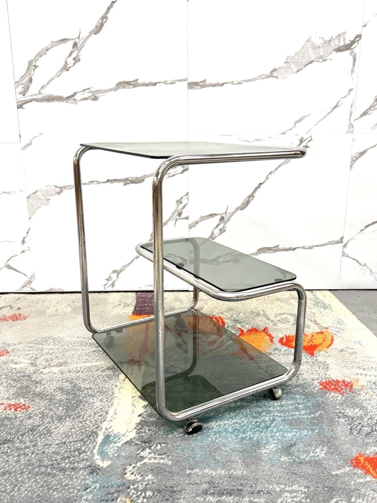 Carrello Portavivande a Tre Ripiani – Design Modernariato Anni ’70


Elegante carrello portavivande degli anni ’70, realizzato in acciaio cromato con tre ripiani in vetro fumé. Il design sinuoso e minimale richiama lo stile modernista tipico del