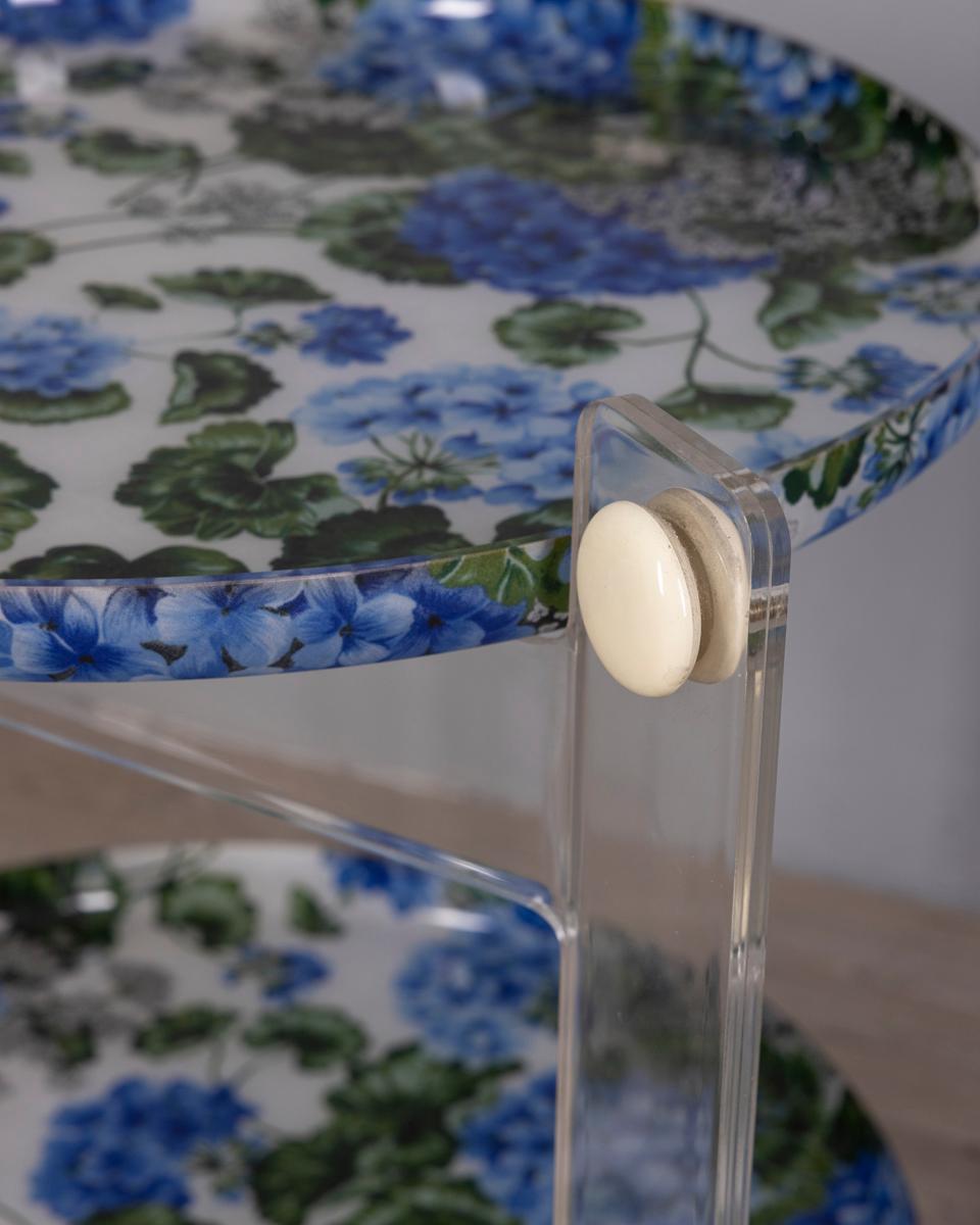 Carrello bar in plastica trasparente con vassoi a tema floreale, disegnato da Luigi Massoni per Guzzini, anni '70.

CONDIZIONE :
En bon état, il peut présenter des traces d'usure dues à son âge.

DIMENSIONI :
Altezza 64 cm ; Larghezza 64 cm ;