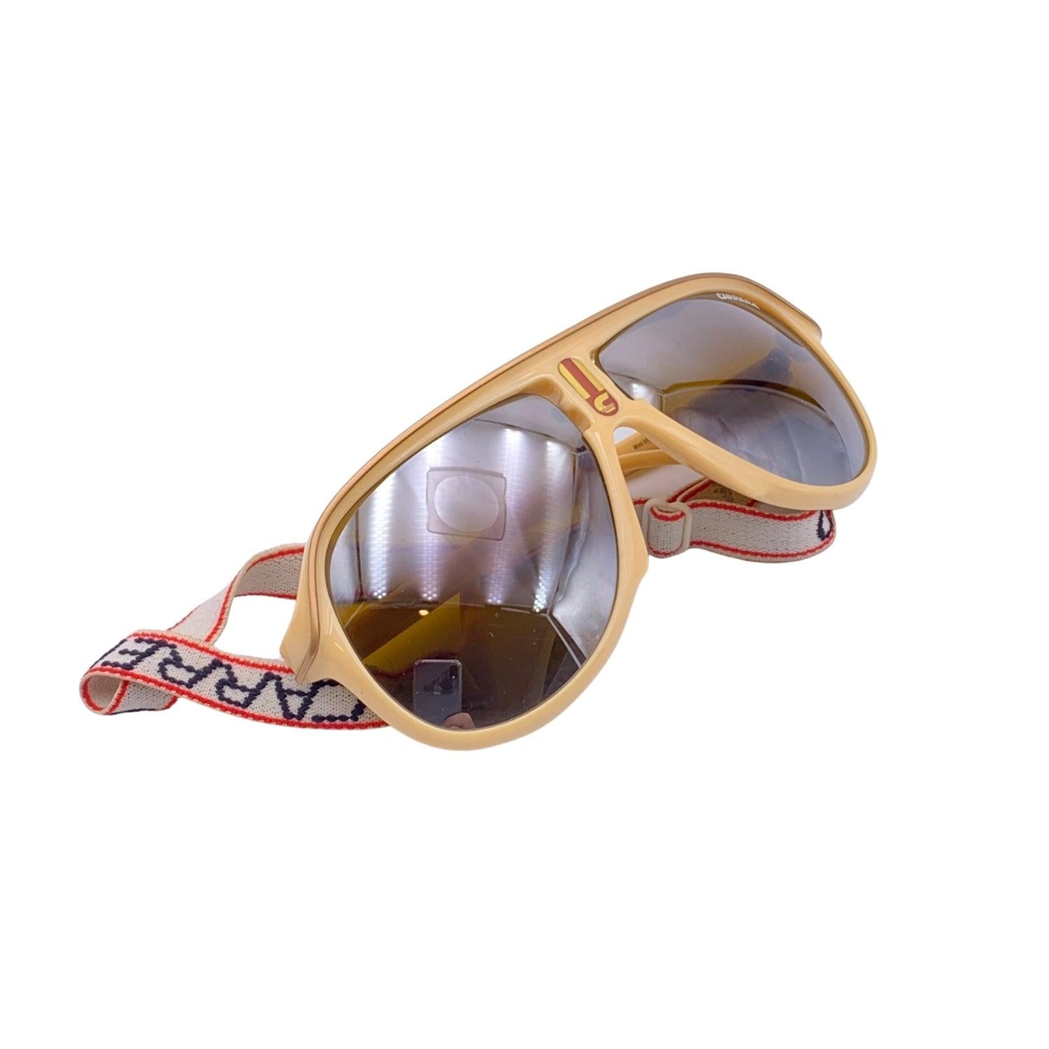 Vintage Carrera Sport Aviator Beige Sunglasses. Model: 5544 70. Size: 63/13 130mm. Beige acetate frame and beige temples with the original elastic band. 100% Total UVA/UVB protection. Gradient Brown lenses. Carrera branding to the bridge and on the