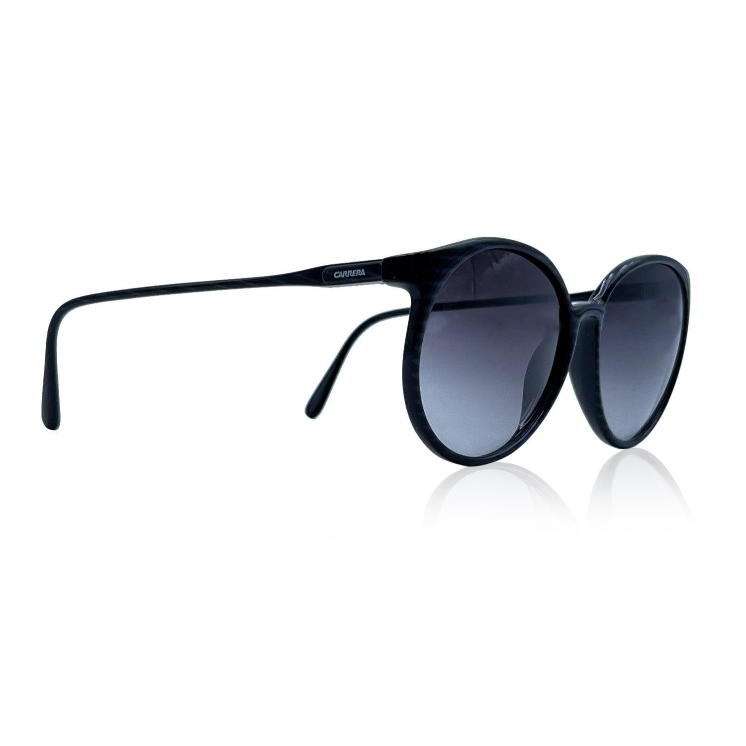 Round, large sunglasses by Carrera. Optyl frame (LCM), in black color, with gray horizontal stripes pattern. Frame made in Austria. Model refs: 5354 - 50 - 58/16 . Gradient grey lens Details MATERIAL: Acetate COLOR: Black MODEL: 5354 GENDER: Women