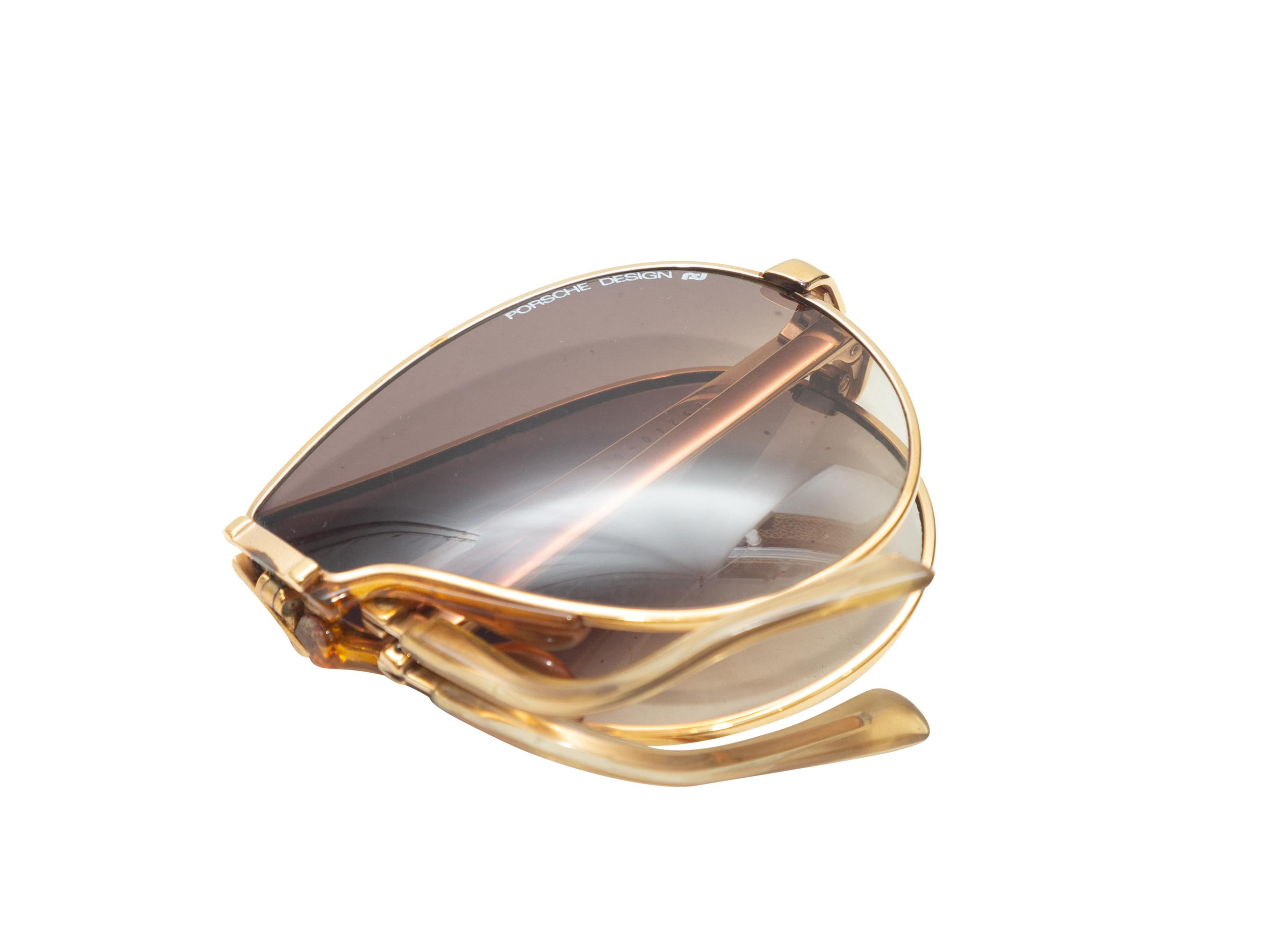 Product details: Vintage gold metal foldable sunglasses by Carrera x Porsche Designs. Grey tinted lenses. 2.25