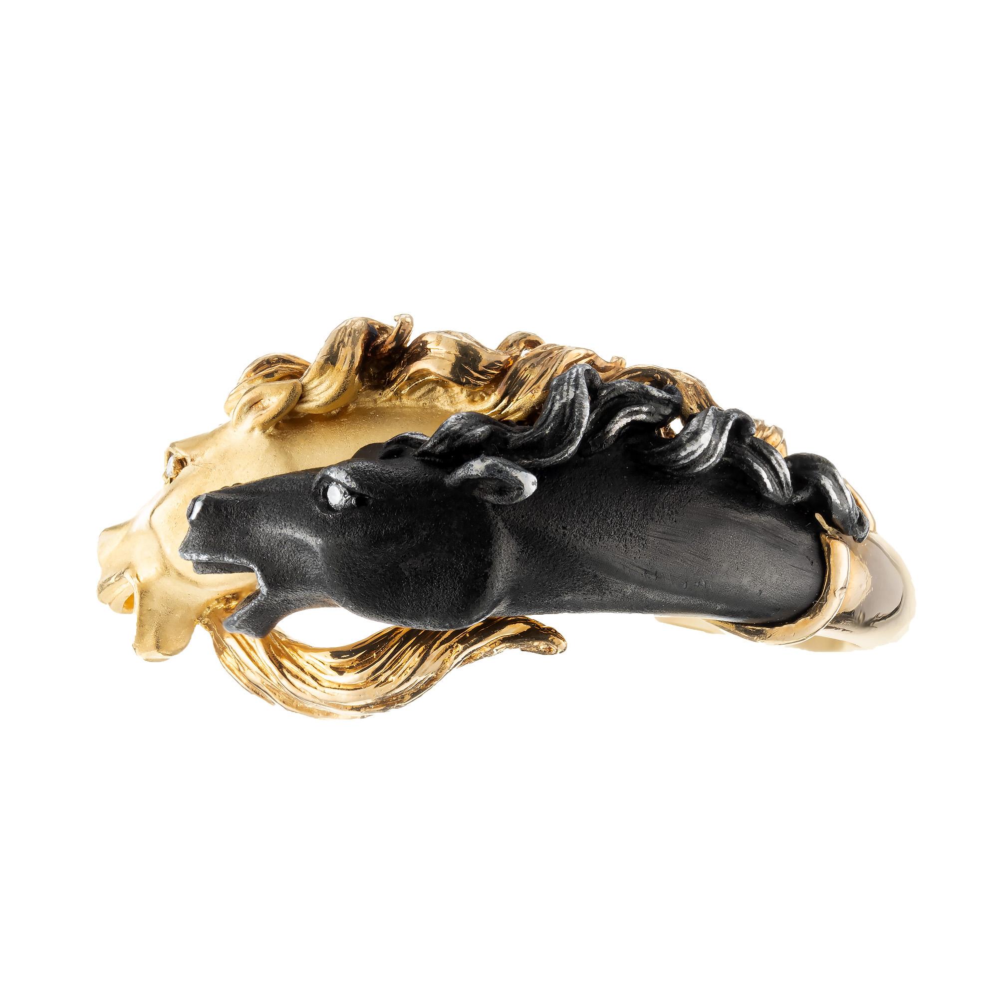 Aus der Carrera y Carrera Pferdekollektion stammt dieser Ring mit doppeltem Pferdekopf aus 18k Gelbgold und dunklem Finish mit 2 Diamantaugen. Größe 12. Werkseitige Originallackierung auf einem Kopf nachgedunkelt. 

2 runde Diamanten im